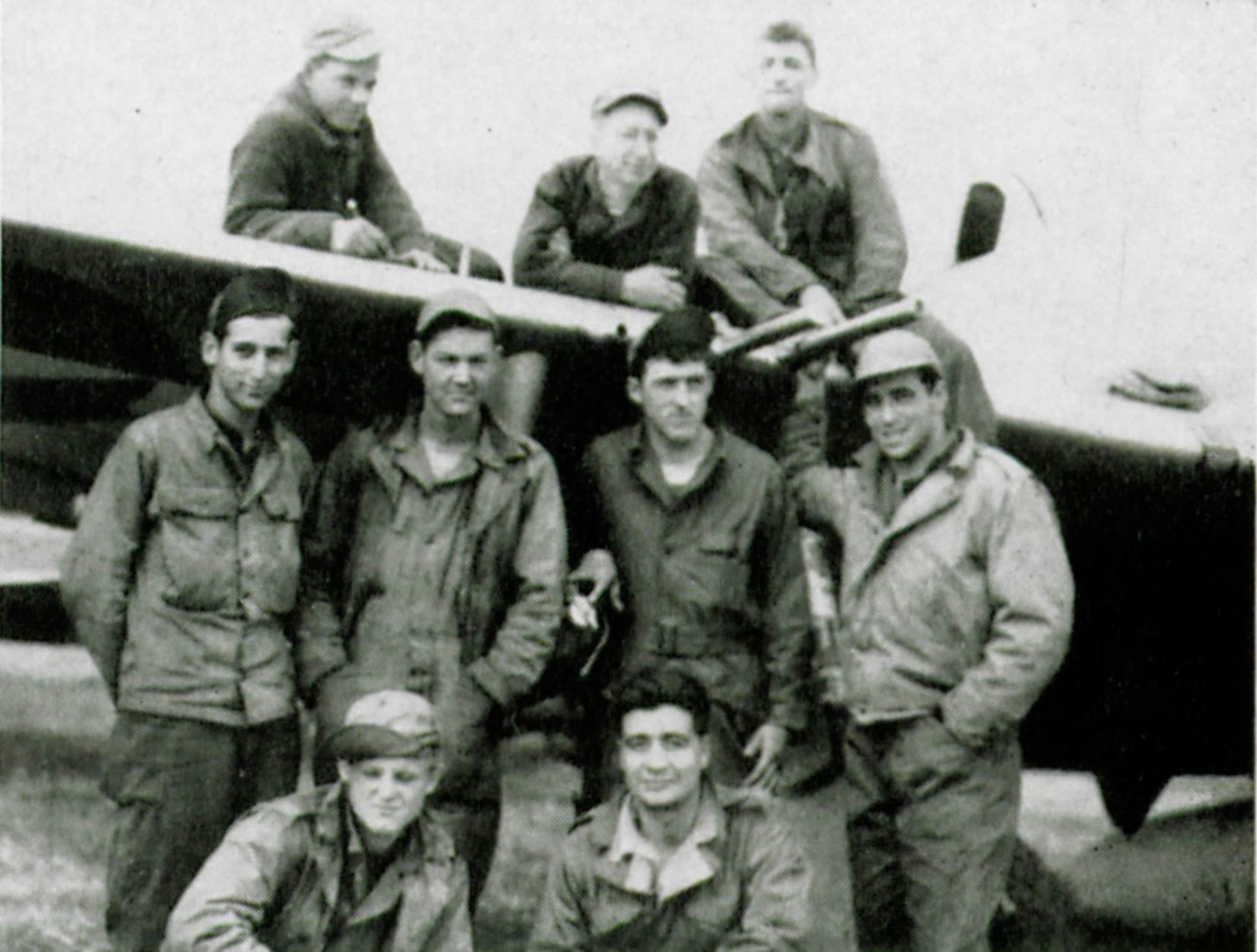 Armorers of the 405th Fighter Squadron such as Sergeant Louis P. Cellitti, third from the left atop the wing of this P-47, loaded relief supplies instead of bombs on the squadron’s P-47 Thunderbolts in order to help the Lost Battalion.  The other men seen in this view are, on wing left to right, Ras Rogers and Earl M. Berkley.  Standing are Benjamin H. Deller, Dan M. Nall, Irving J. Gnehm and Earnest P. Toma.  Kneeling are Rudolph D. Jennings and Albert Martinez.  (The Story of the 371st Fighter Group in the E.T.O., page 126)


