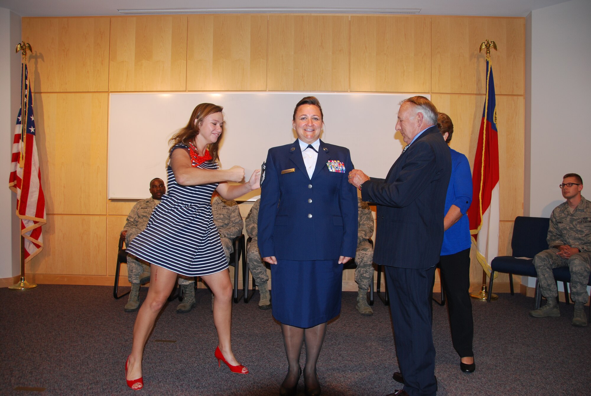 U.S. Air National Guard Chief Master Sgt. Angela Zephier, superintendent of the 156th Weather Flight, gets the rank of Chief tacked on by daughter Sarah, and father, retired Chief Warrant Officer (4) Larry Deal, during her promotion ceremony held at the 145th Combat Operations Group, New London, N.C. October 4, 2014. (U.S. Air National Guard photo by Master Sgt. Matthew Ciampa, 145th Weather Flight/Released)