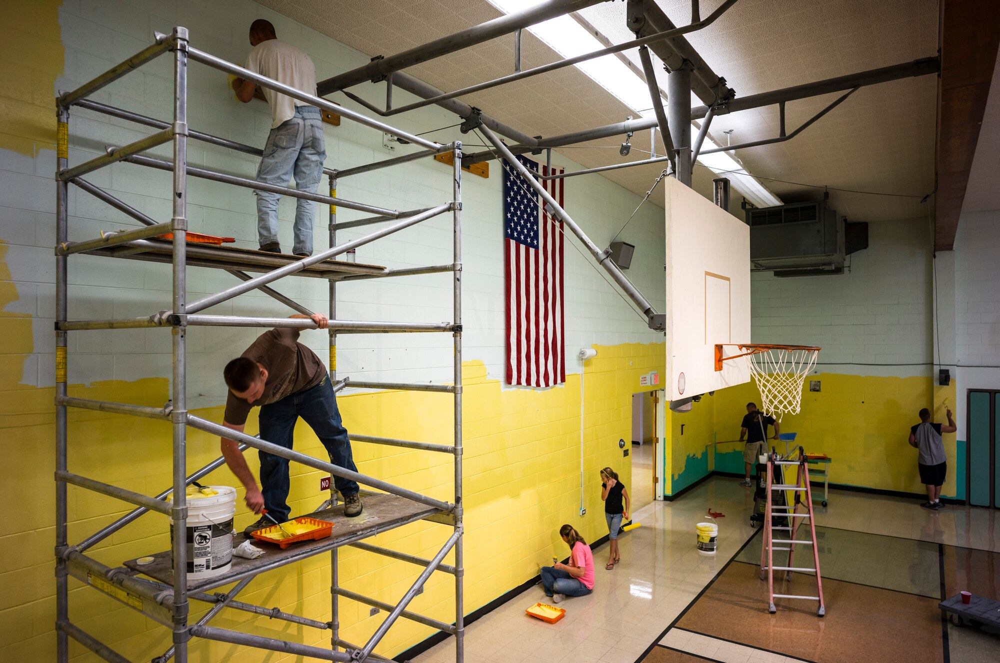 Volunteers paint the gym at Stephensen Elementary School at Mountain Home Air Force Base, Idaho, August 9, 2014. More than 150 volunteers gathered to paint both the interior and exterior of the building before the start of a new school year. (U.S. Air Force photo by Tech. Sgt. Samuel Morse/RELEASED)