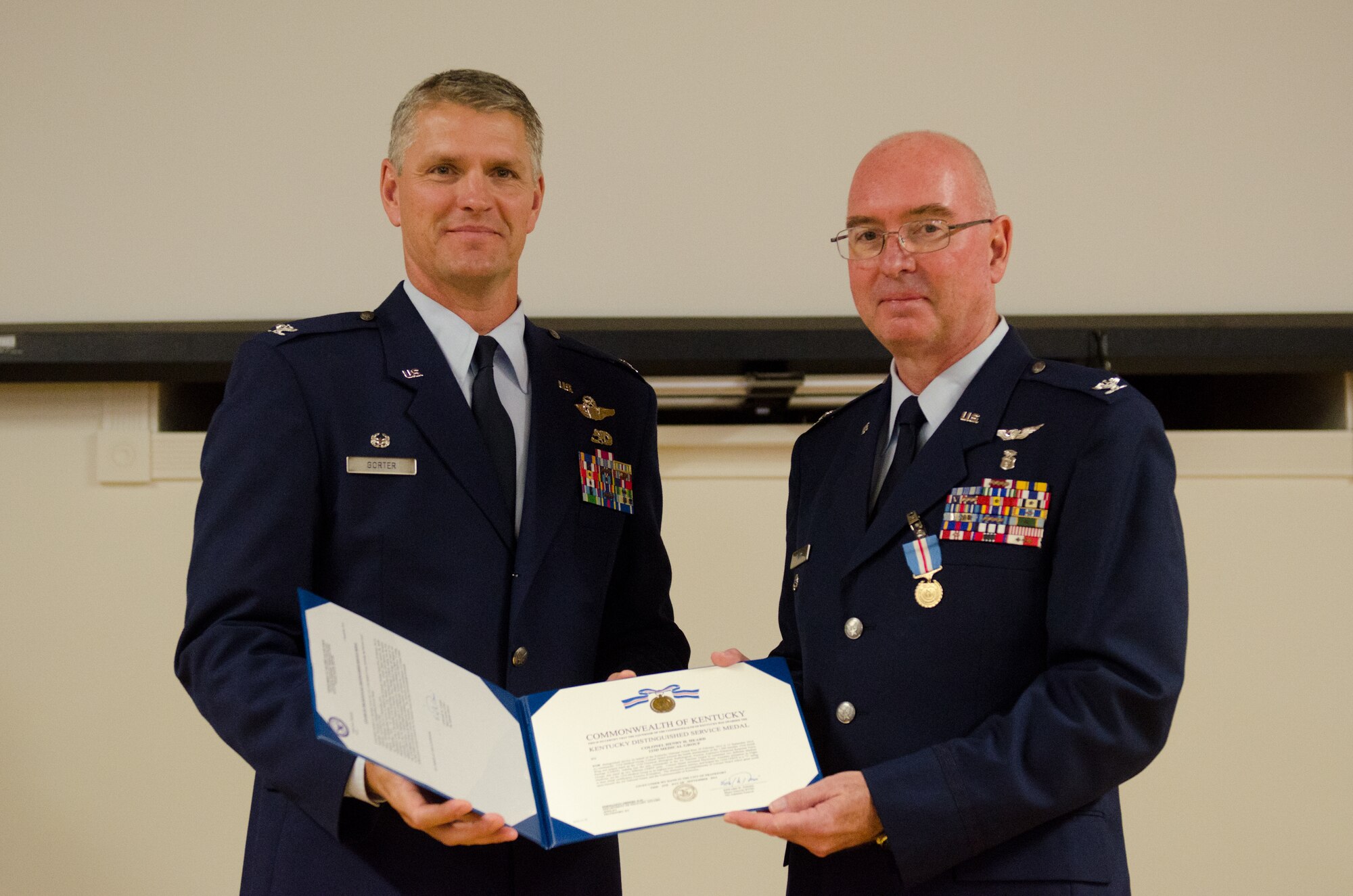 Col. Henry Heard (right), the outgoing commander of the 123rd Medical Group, receives the Kentucky Distinguished Service Medal from Col. Barry Gorter, commander of the 123rd Airlift Wing, during Heard’s retirement ceremony at the Kentucky Air National Guard Base in Louisville, Ky., Sept. 13, 2014. Heard is retiring after more than two decades of service to the Air Force Reserve and Air National Guard. (U.S. Air National Guard photo by Senior Airman Joshua Horton)