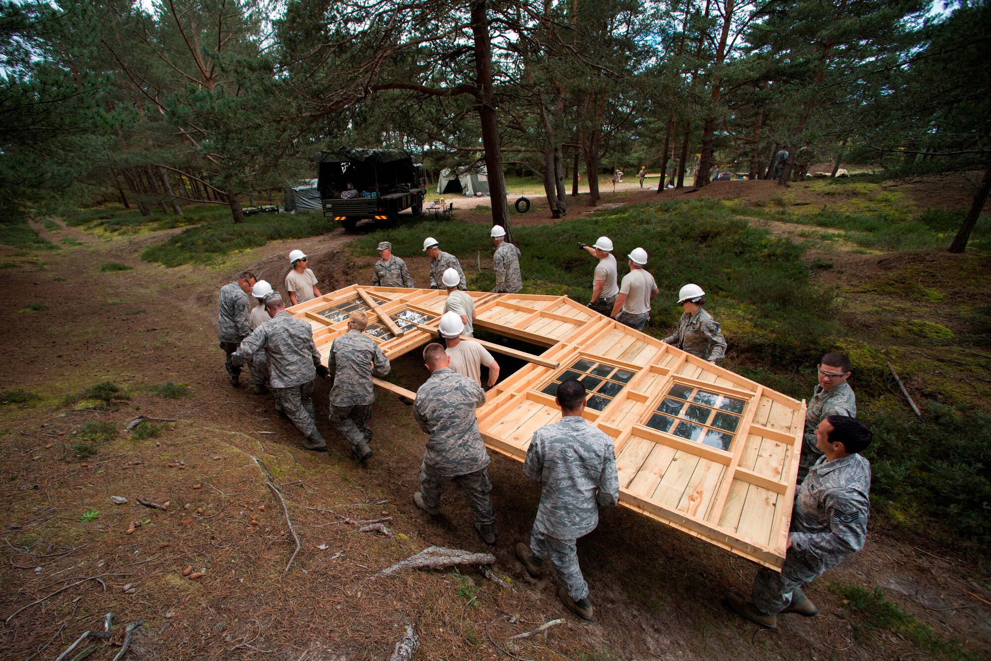 U.S. Airmen from the 140th Civil Engineer Squadron, Colorado Air National Guard, carry the front wall away from the small single room structure that is being taken apart and reassembled later in a more suitable location, during their deployed for training trip, known as Exercise Flying Rose at Kinloss Barrack in Forres, Moray, Scotland, United Kingdom, Jun. 11, 2014. Over 40 members of the 140th CES are in Scotland for their annual training and are accomplishing five construction projects that will improve several areas around Kinloss Barracks, during Exercise Flying Rose hosted by the British Army before returning back to Colorado later this month. (U.S. Air National Guard photo/Tech. Sgt. Wolfram M. Stumpf)