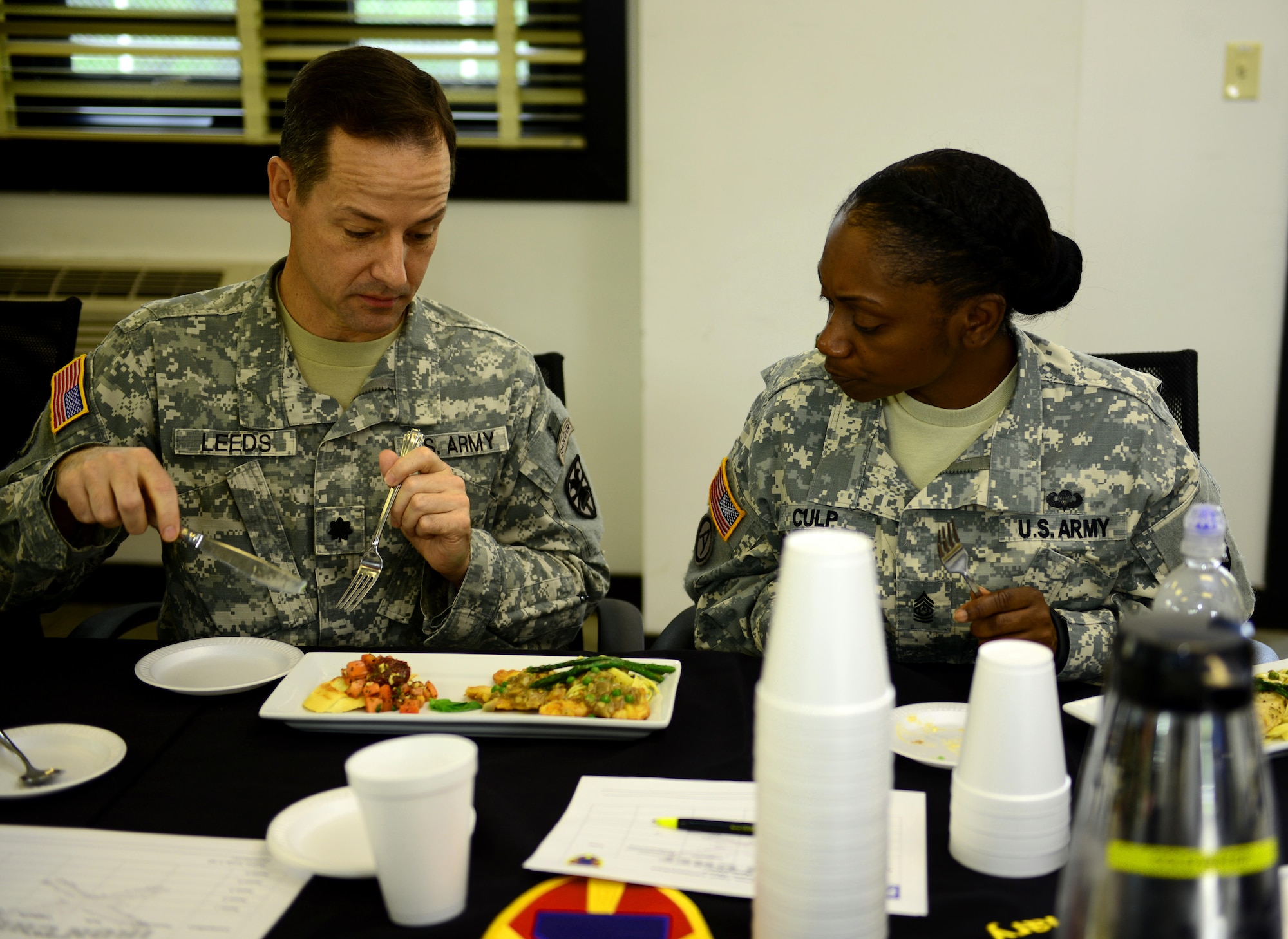 U.S. Army Lt. Col. Kenneth Leeds, 7th Transportation Brigade (Expeditionary) deputy commanding officer, and Command Sgt. Maj. Vickie Culp, 7th Trans. Bde. (Ex.) sergeant major, taste-test food  during a two-day Iron Chef competition at Fort Eustis, Va., Oct. 29, 2014. Commanders and sergeants major from several battalions assisted in the taste-testing.  (U.S. Air Force photo by Airman 1st Class Kimberly Nagle/Released)