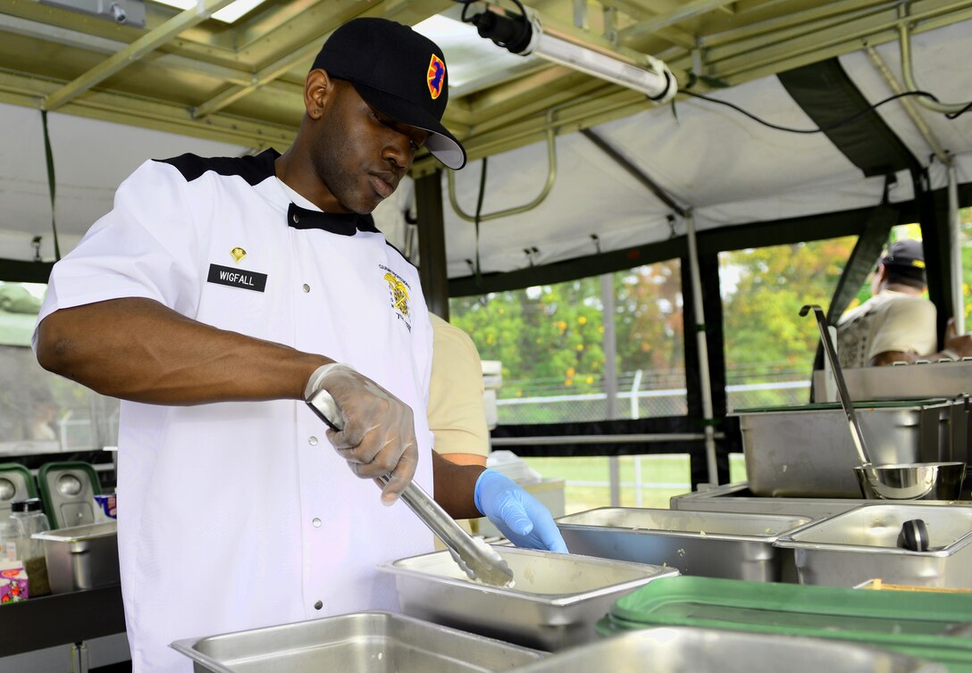 U.S. Army Spc. Monet Wigfall, 155th Inland Cargo Transportation Company, 53rd Movement Control Battalion, 7th Transportation Brigade (Expeditionary) food service specialist, flours chicken during a two-day Iron Chef competition at Fort Eustis, Va., Oct. 29, 2014. The competition tested four-man teams of Soldiers not only on their culinary skills, but their Soldier skills as well. (U.S. Air Force photo by Airman 1st Class Kimberly Nagle/Released)
