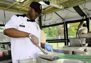U.S. Army Spc. Monet Wigfall, 155th Inland Cargo Transportation Company, 53rd Movement Control Battalion, 7th Transportation Brigade (Expeditionary) food service specialist, flours chicken during a two-day Iron Chef competition at Fort Eustis, Va., Oct. 29, 2014. The competition tested four-man teams of Soldiers not only on their culinary skills, but their Soldier skills as well. (U.S. Air Force photo by Airman 1st Class Kimberly Nagle/Released)
