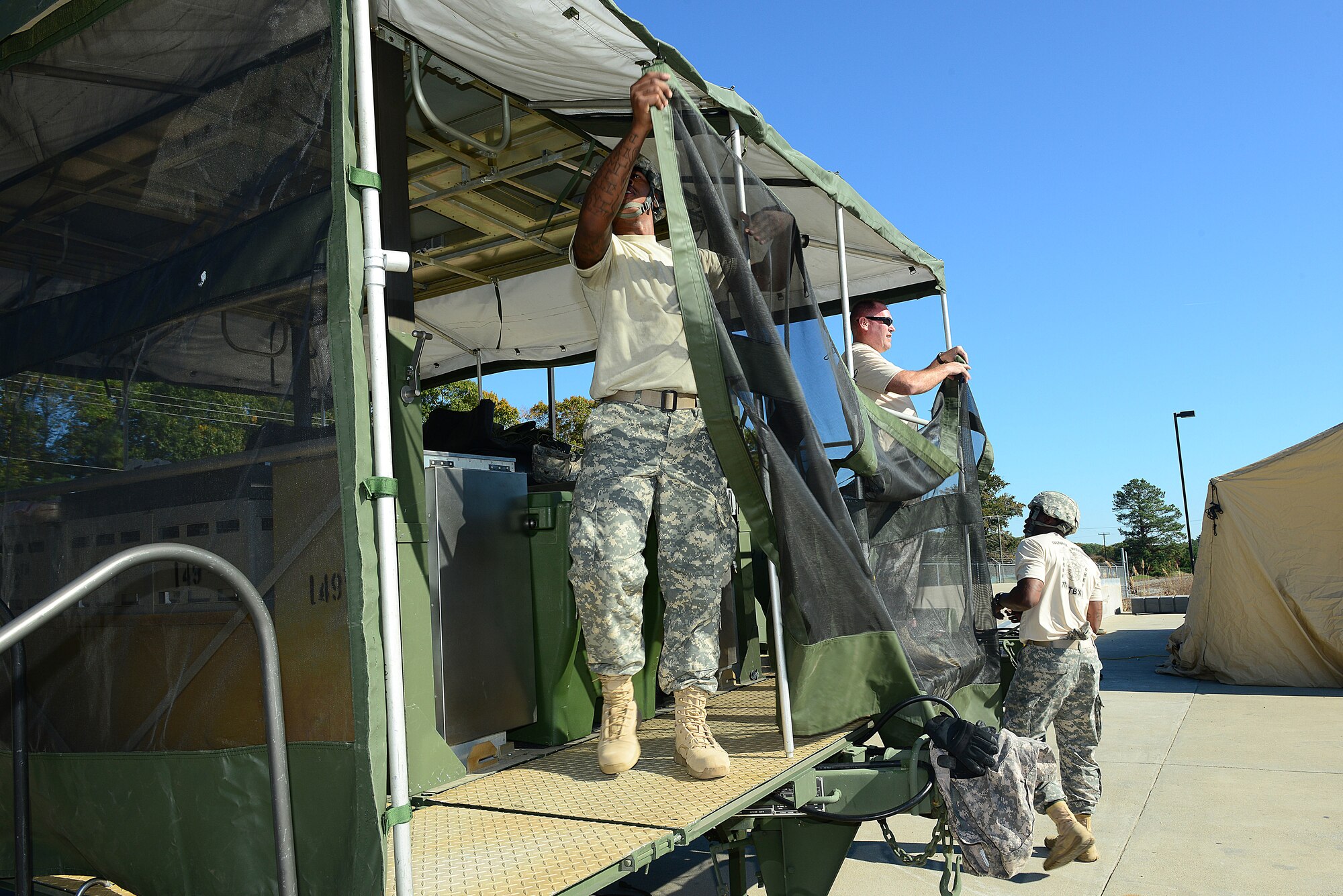 U.S. Army Soldiers assigned to the 7th Transportation Brigade (Expeditionary) set up a mobile kitchen trailer (MKT) as part of a two-day Iron Chef competition at Fort Eustis, Va., Oct. 28, 2014. The Soldiers had to construct their MKTs to prepare the competition meals the following day. (U.S. Air Force photo by Airman 1st Class Kimberly Nagle/Released)