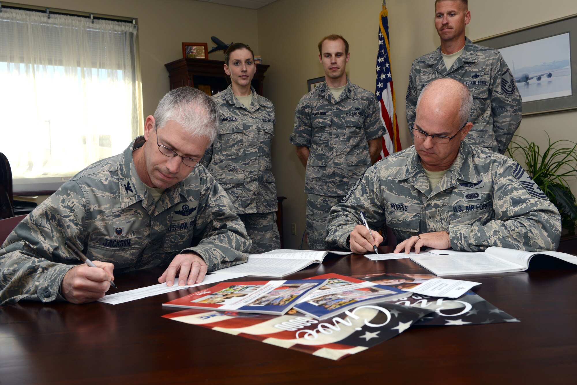 Col. Joel Jackson, 22nd Air Refueling Wing commander and Chief Master Sgt. Michael Morris, 22nd ARW command chief, sign their Combined Federal Campaign donations, Oct. 20, 2014, McConnell Air Force Base, Kan. The CFC is a fundraising campaign targeted at federal employees, and gives them the opportunity to donate to various charities. (U.S. Air Force photo/Senior Airman Trevor Rhynes)