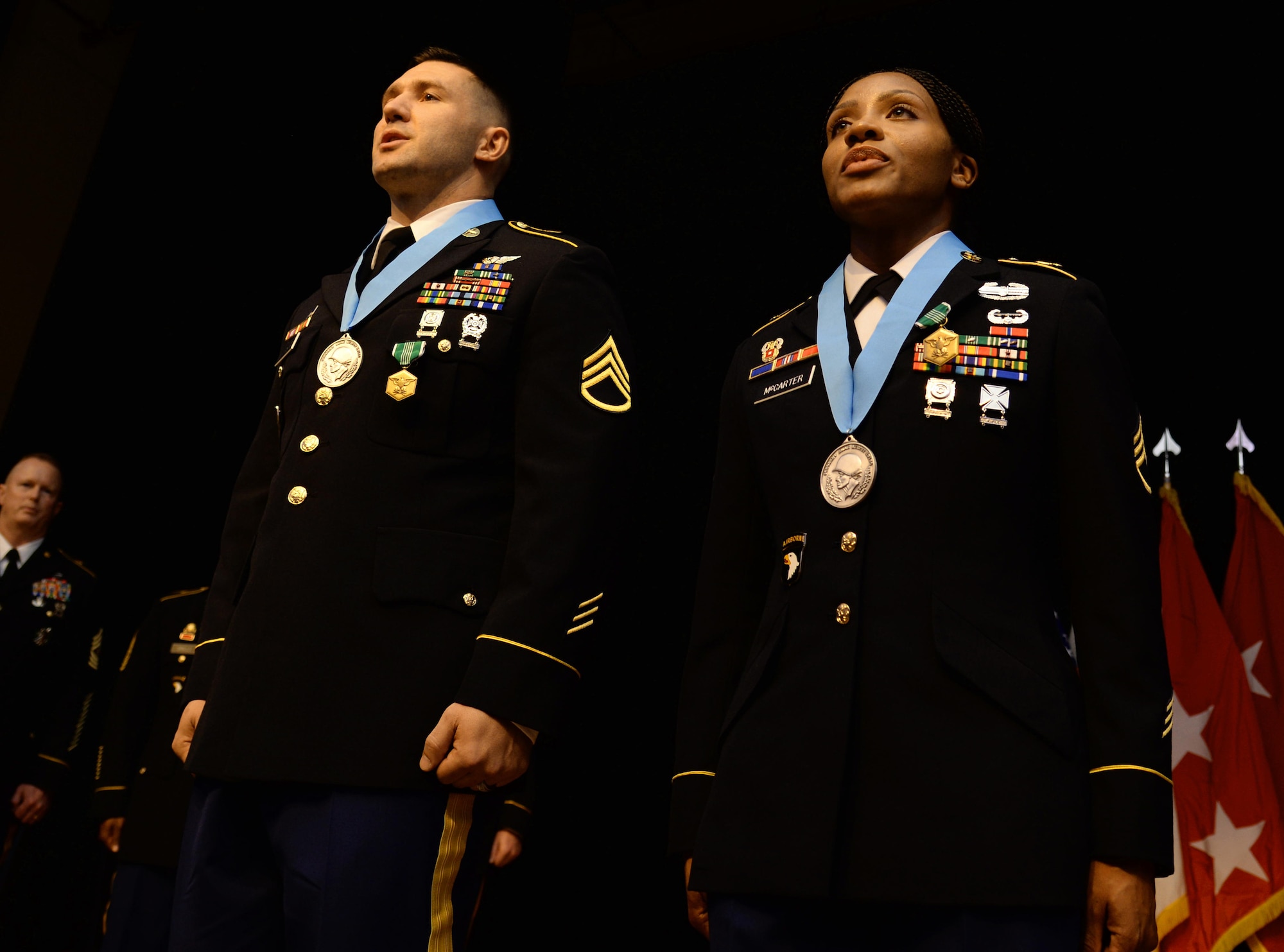U.S. Army Staff Sgts. Thomas Featsent and Retina McCarter, both Sergeant Audie Murphy Club inductees, sing the Army Song during a Sergeant Audie Murphy Club induction ceremony at Fort Eustis, Va., Oct. 29, 2014. An inductee's subordinate Soldier introduces the inductee before the medal presentation to show the bond between active front-line supervisors and the Soldiers they look after. (U.S. Air Force photo by Senior Airman Austin Harvill/Released)