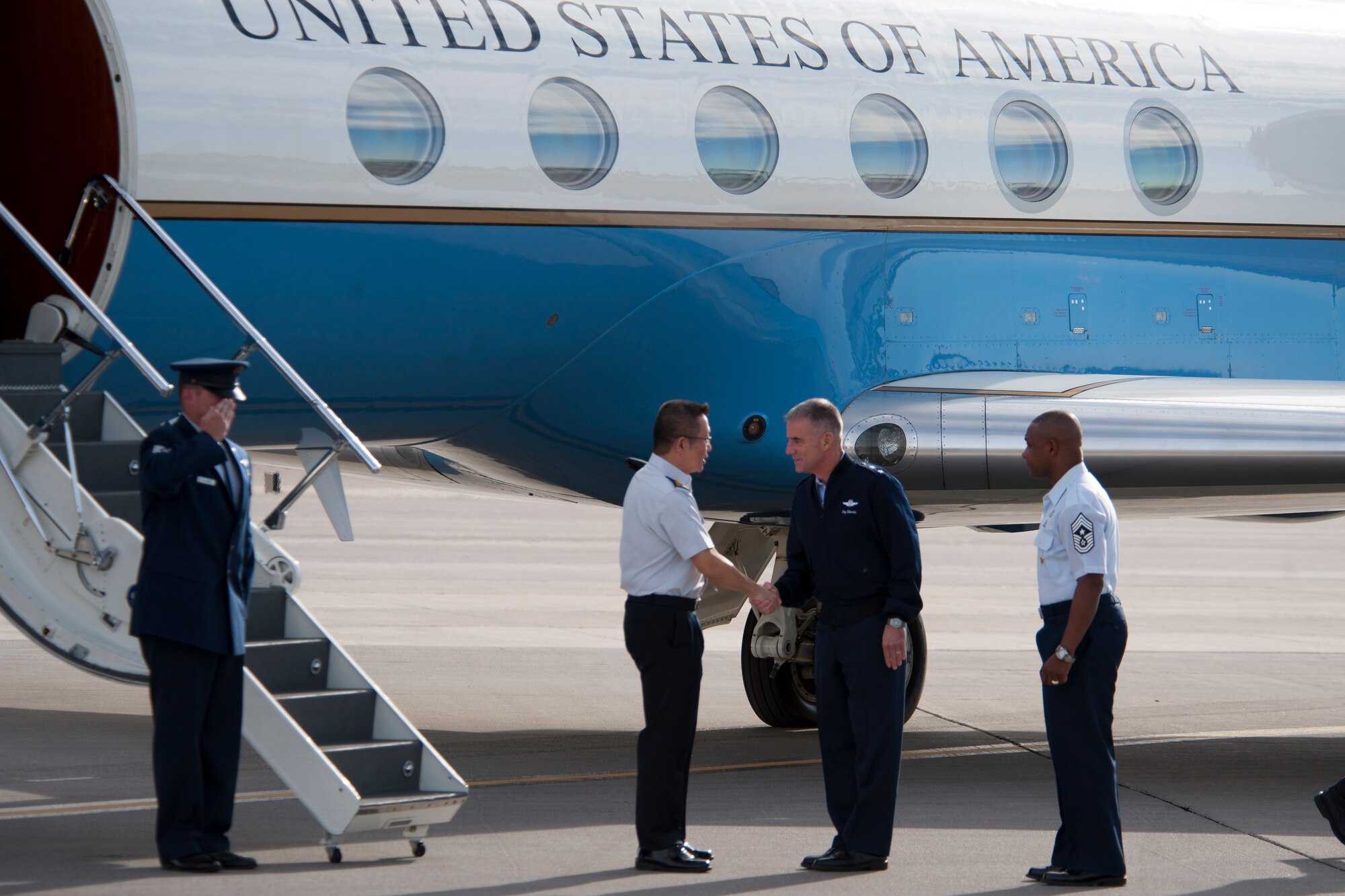Maj. Gen. Hoo Cher Mou, Chief of Air Force, Republic of Singapore, is greeted by Maj. Gen. Jay Silveria, U.S. Air Force Warfare Center commander, and Chief Master Sgt. Kenneth Lindsey, USAFWC command chief, on the flightline at Nellis Air Force Base, Nev., Oct. 23, 2014. Nellis AFB was one of several bases Hoo was visiting around the U.S. (U.S. Air Force photo by Lorenz Crespo)