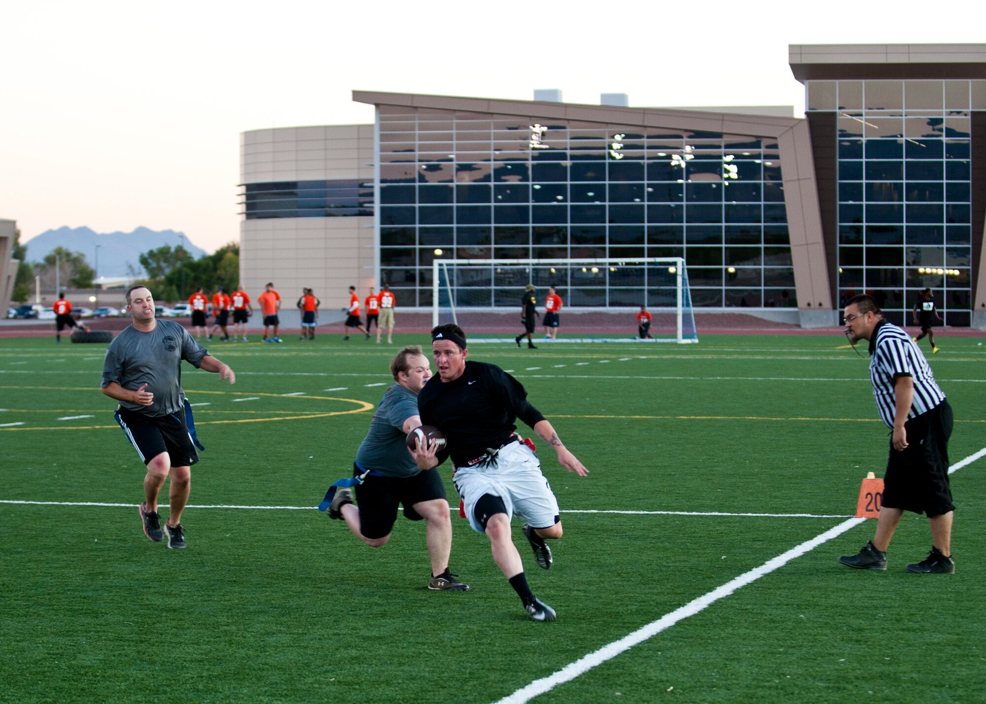 Skylar Perkins, 823rd Maintenance Squadron crew chief, evades opponents during their 7-6 flag football game loss against the 6th Combat Training Squadron at the Warrior Fitness Center, Nellis Air Force Base, Nev., Oct. 28, 2014. Teams from different units and squadrons around base compete against one another in flag football to bolster teamwork and morale. (U.S. Air Force photo by Airman 1st Class Thomas Spangler)