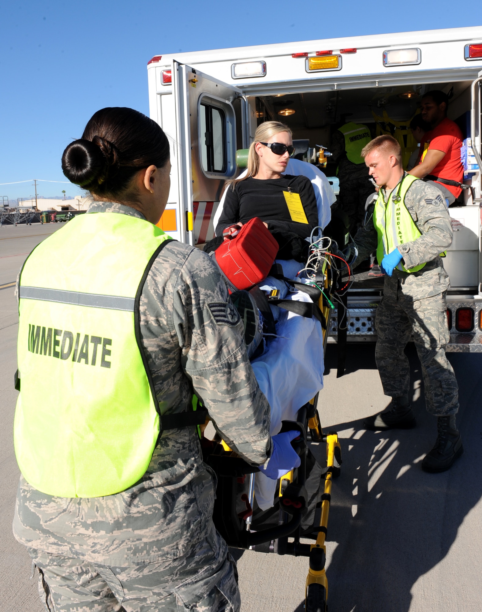 A simulated casualty is wheeled to an ambulance for transport during the major accident response exercise at Nellis Air Force Base, Nev., Oct. 28, 2014. Airmen are made-up with false injuries to simulate casualties during a large-scale accident. (U.S. Air Force photo by Staff Sgt. Victoria Sneed)