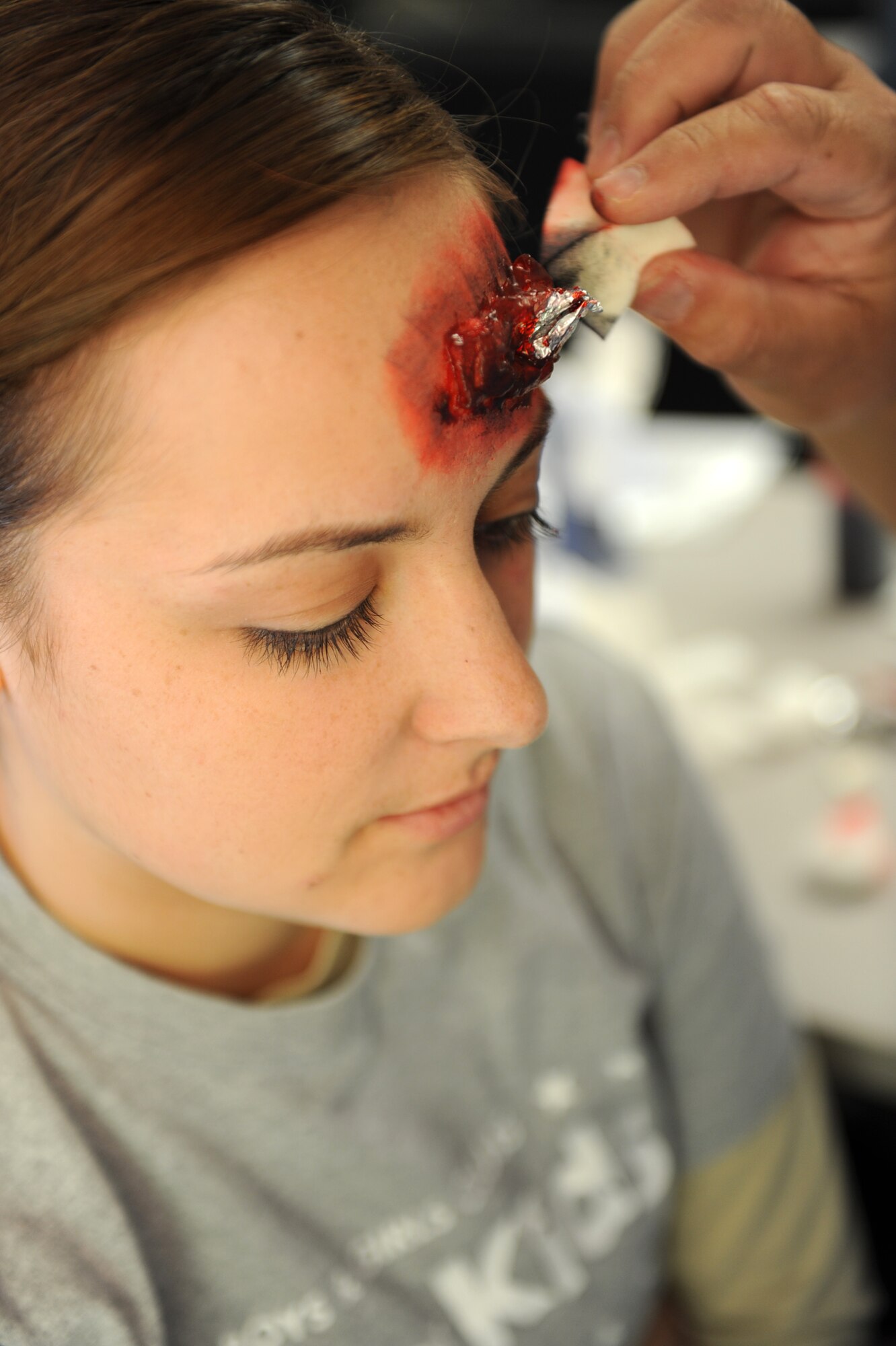Fake blood is sponged onto a casualties’ simulated shrapnel wound in preparation for the major accident response exercise at Nellis Air Force Base, Nev., Oct. 28, 2014. Medical group personnel are trained to apply these fake wounds to allow responders to react the way they would to a real victim. (U.S. Air Force photo by Staff Sgt. Victoria Sneed)