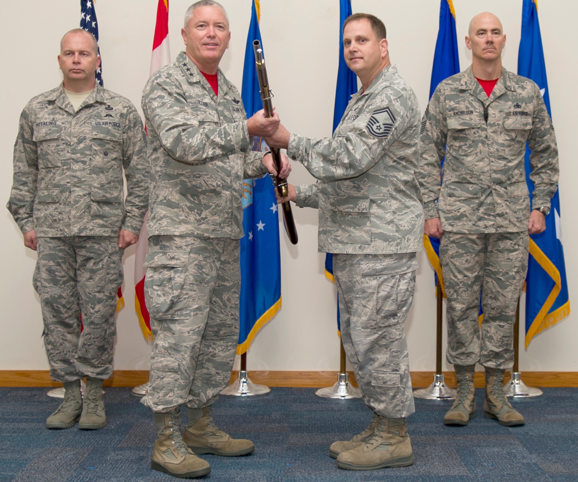 Lt. Gen. William Etter, Commander, Continental U.S. North American Aerospace Defense Region-1st Air Force (Air Forces Northern), accepts the presentation of  a 1600-era replica musket from Combined Enlisted Association member, Senior Master Sgt. Paul Williams while Chief Master Sgt. James Hotaling, Air National Guard Command Chief, (left) and Chief Master Sgt. Ronald Anderson, CONR-1st AF (AFNORTH) Command Chief, remain at attention. The CEA presented the musket to the organization as a tribute to acknowledge the nation’s military heritage and commitment to the defense of freedom. (Photo by Airman 1st Class Ty Rico Lea)