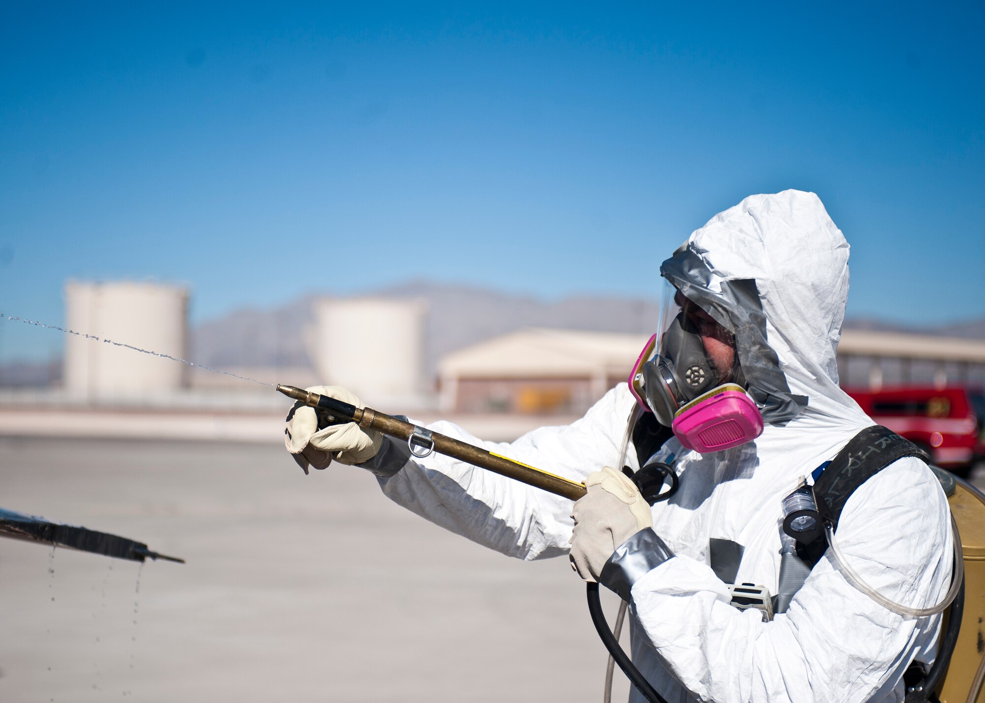A crash recovery technician from the 57th Maintenance Group sprays down an F-16 Fighting Falcon that is playing the role of an F-35A Lightning II during a major accident response exercise at Nellis Air Force Base, Nev., Oct. 28, 2014. Crash recovery’s role in any aircraft accident is to safely retrieve, remove and relocate the downed aircraft from its crash site to a secure holding site. (U.S. Air Force photo by Staff Sgt. Siuta B. Ika)