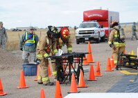Firefighters from the Malmstrom Air Force Base Fire Department set up a portable stretcher for use in a decontamination wash station during an exercise at the base Oct. 27, 2014.  The exercise was part of Global Thunder 15, a U.S. Strategic Command annual field training and battle staff exercise designed to exercise all mission areas with primary emphasis on nuclear command, control and communications. This field training and battle staff exercise provides training opportunities for components, task forces, units, and command posts to deter and, if necessary, defeat a military attack against the United States and to employ forces as directed by the president. (U.S. Air Force photo/Christy Mason)