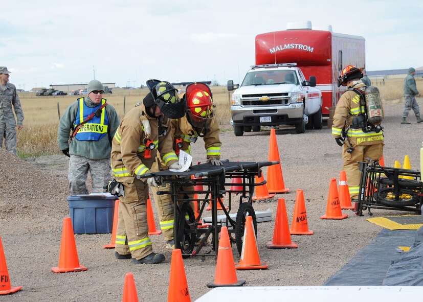 Firefighters from the Malmstrom Air Force Base Fire Department set up a portable stretcher for use in a decontamination wash station during an exercise at the base Oct. 27, 2014.  The exercise was part of Global Thunder 15, a U.S. Strategic Command annual field training and battle staff exercise designed to exercise all mission areas with primary emphasis on nuclear command, control and communications. This field training and battle staff exercise provides training opportunities for components, task forces, units, and command posts to deter and, if necessary, defeat a military attack against the United States and to employ forces as directed by the president. (U.S. Air Force photo/Christy Mason)