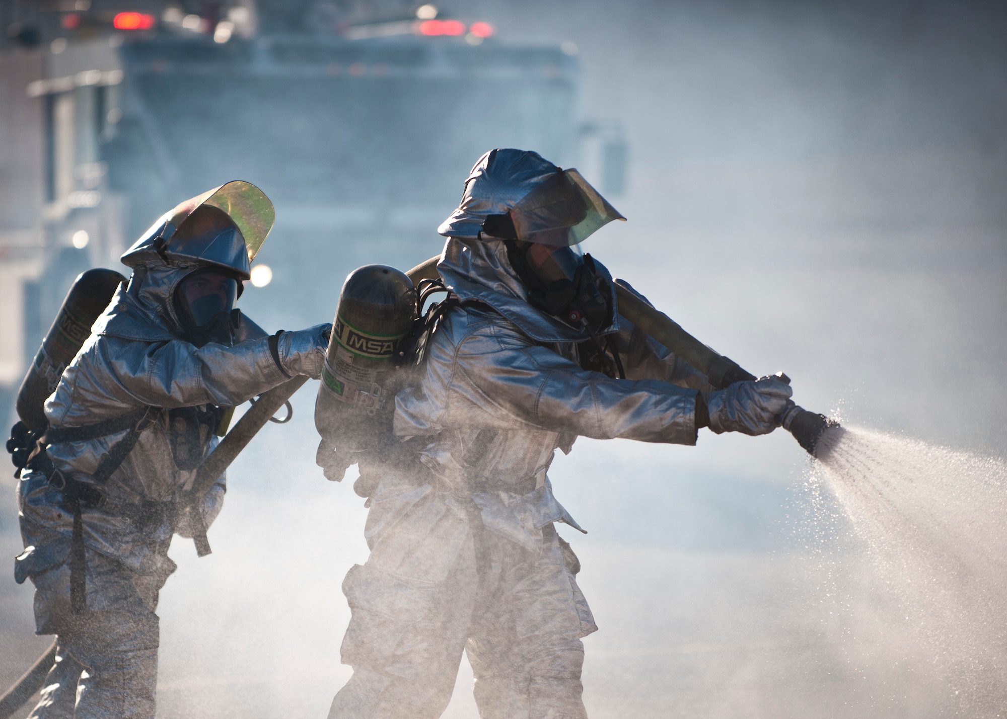 Firefighters from the 99th Civil Engineer Squadron drag a fire hose to the scene of a simulated aircraft crash site during a major accident response exercise at Nellis Air Force Base, Nev., Oct. 28, 2014. The MARE tested first responders’ skills in a controlled environment to give responders confidence in handling the event in a real-world situation. (U.S. Air Force photo by Staff Sgt. Siuta B. Ika)