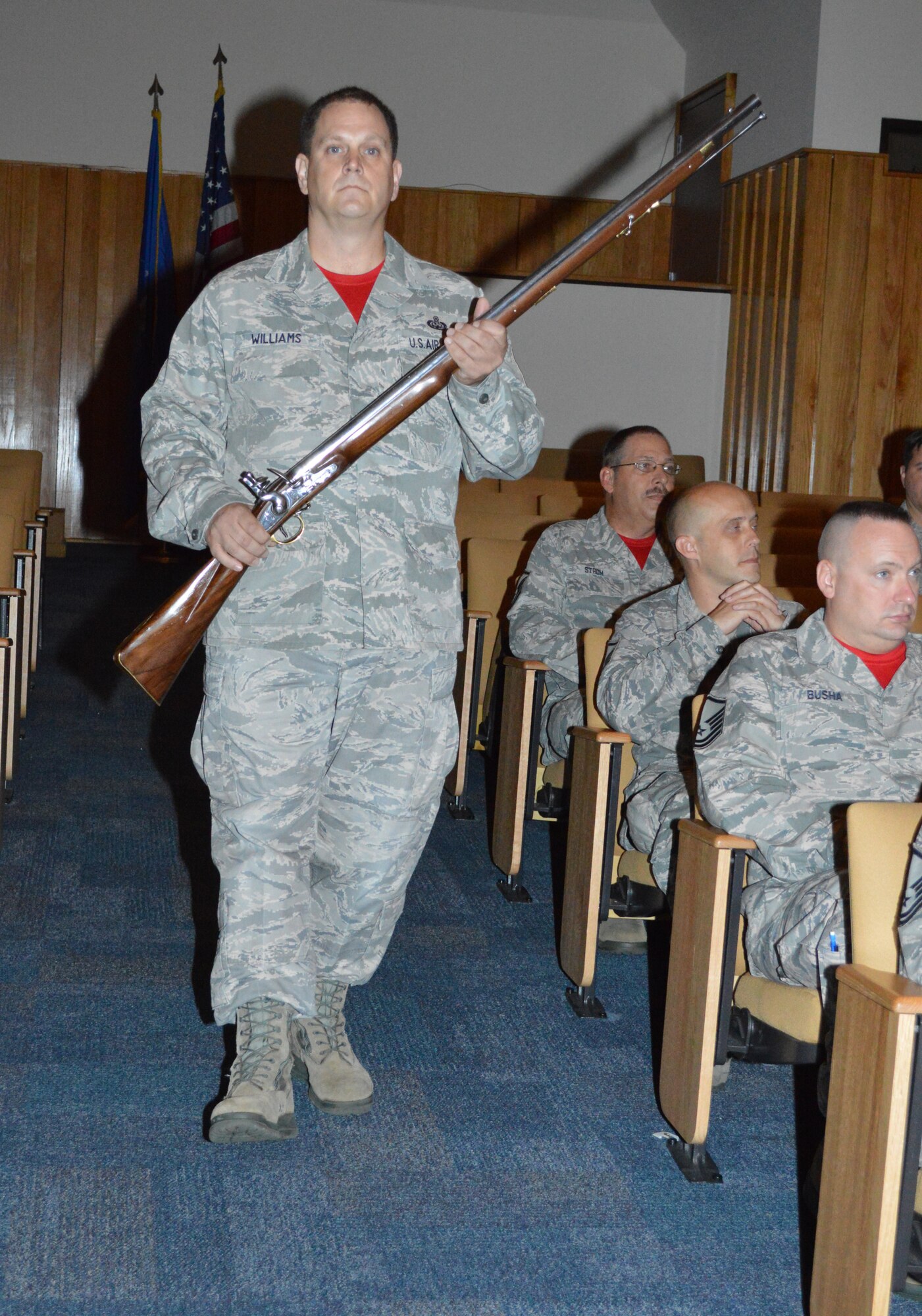 : Senior Master Sgt. Paul Williams, Combined Enlisted Association member, walks down the aisle on his way to present the replica musket to the Continental U.S. North American Aerospace Defense Region-1st Air Force (Air Forces Northern) organization. The CEA presented the musket to the organization as a tribute to acknowledge the nation’s military heritage and commitment to the defense of freedom. (Photo by Mary McHale)