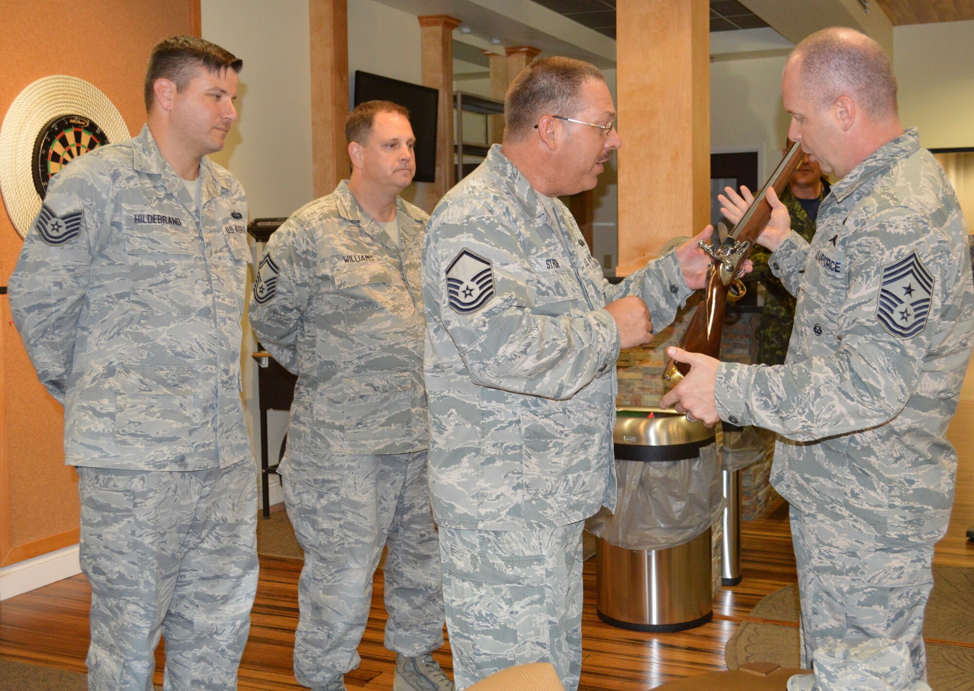 Tech. Sgt. Marcel  Hildebrand (left) and Senior Master Sgt. Paul Williams, Combined Enlisted Association members,  watch as Master Sgt. Todd Stroh, also a CEA member, explains some points about the replica musket’s trigger operation to Chief Master Sgt. James Hotaling, Air National Guard Command Chief. Hotaling was at 1st Air Force for a visit Oct. 9-10. (Photo by Mary McHale)
