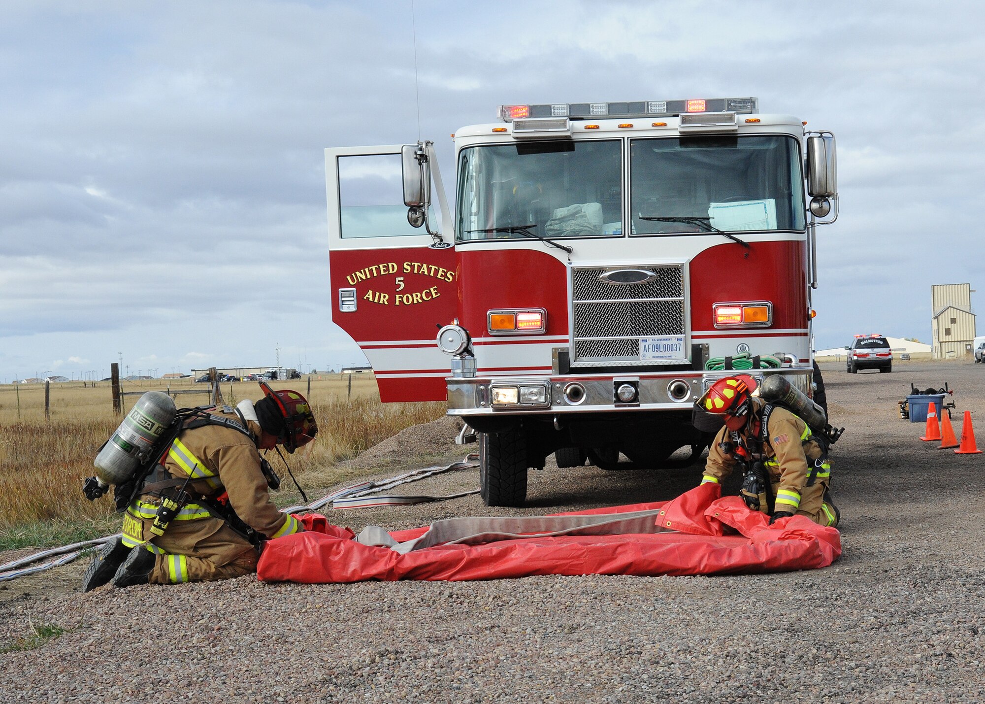 Firefighters from the Malmstrom Air Force Base Fire Department work together to set up a secondary decontamination wash station during an exercise at the base Oct. 27, 2014.  The exercise was part of Global Thunder 15, a U.S. Strategic Command annual field training and battle staff exercise designed to exercise all mission areas with primary emphasis on nuclear command, control and communications. This field training and battle staff exercise provides training opportunities for components, task forces, units, and command posts to deter and, if necessary, defeat a military attack against the United States and to employ forces as directed by the president. (U.S. Air Force photo/Christy Mason)