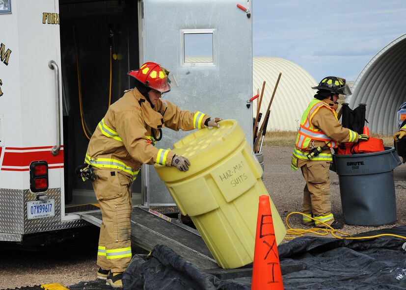 Firefighters from the Malmstrom Air Force Base Fire Department work together to set up a decontamination line during an exercise at the base Oct. 27. The exercise was part of Global Thunder 15, a U.S. Strategic Command annual field training and battle staff exercise designed to exercise all mission areas with primary emphasis on nuclear command, control and communications. This field training and battle staff exercise provides training opportunities for components, task forces, units, and command posts to deter and, if necessary, defeat a military attack against the United States and to employ forces as directed by the president. (U.S. Air Force photo/Christy Mason)