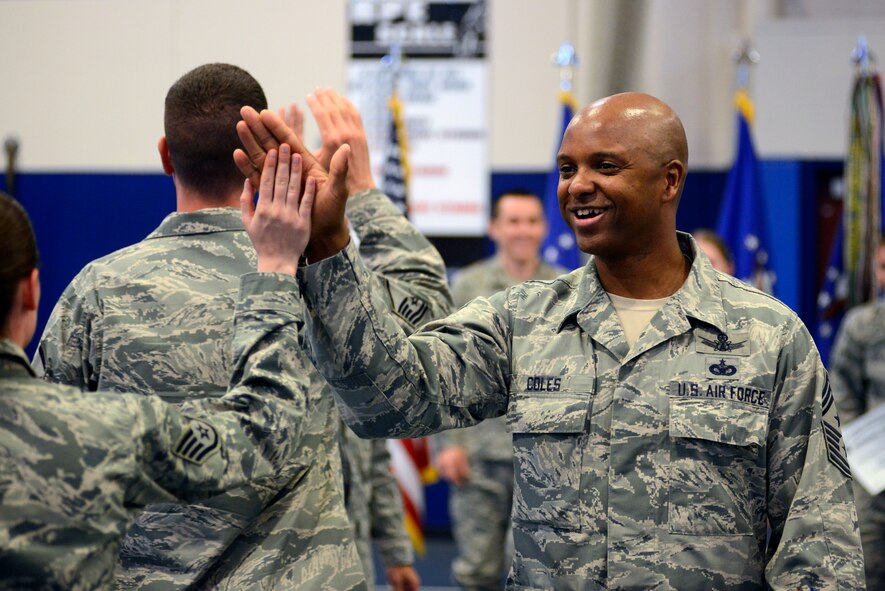 Chief Master Sgt. Lavon Coles, 50th Space Wing command chief, congratulates wing personnel during the unit effectiveness inspection out brief at the Schriever Fitness Center Oct. 28, 2014, at Schriever Air Force Base, Colo. The Masters of Space earned an UEI overall score of “Effective.”(Air Force Photo/Christopher DeWitt)