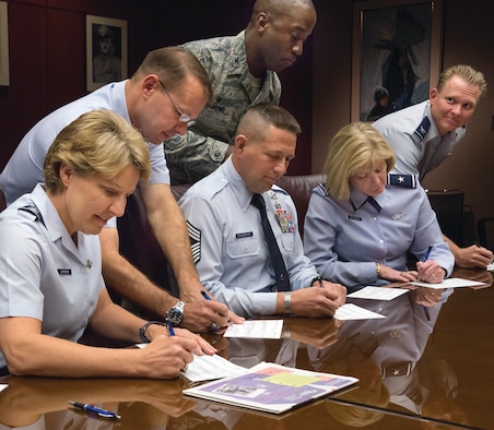 Academy Superintendent Lt. Gen. Michelle D. Johnson (left) and other senior Academy leaders sign their Combined Federal Campaign donation forms here Oct. 22, 2014. (U.S. Air Force photo/Liz Copan) 