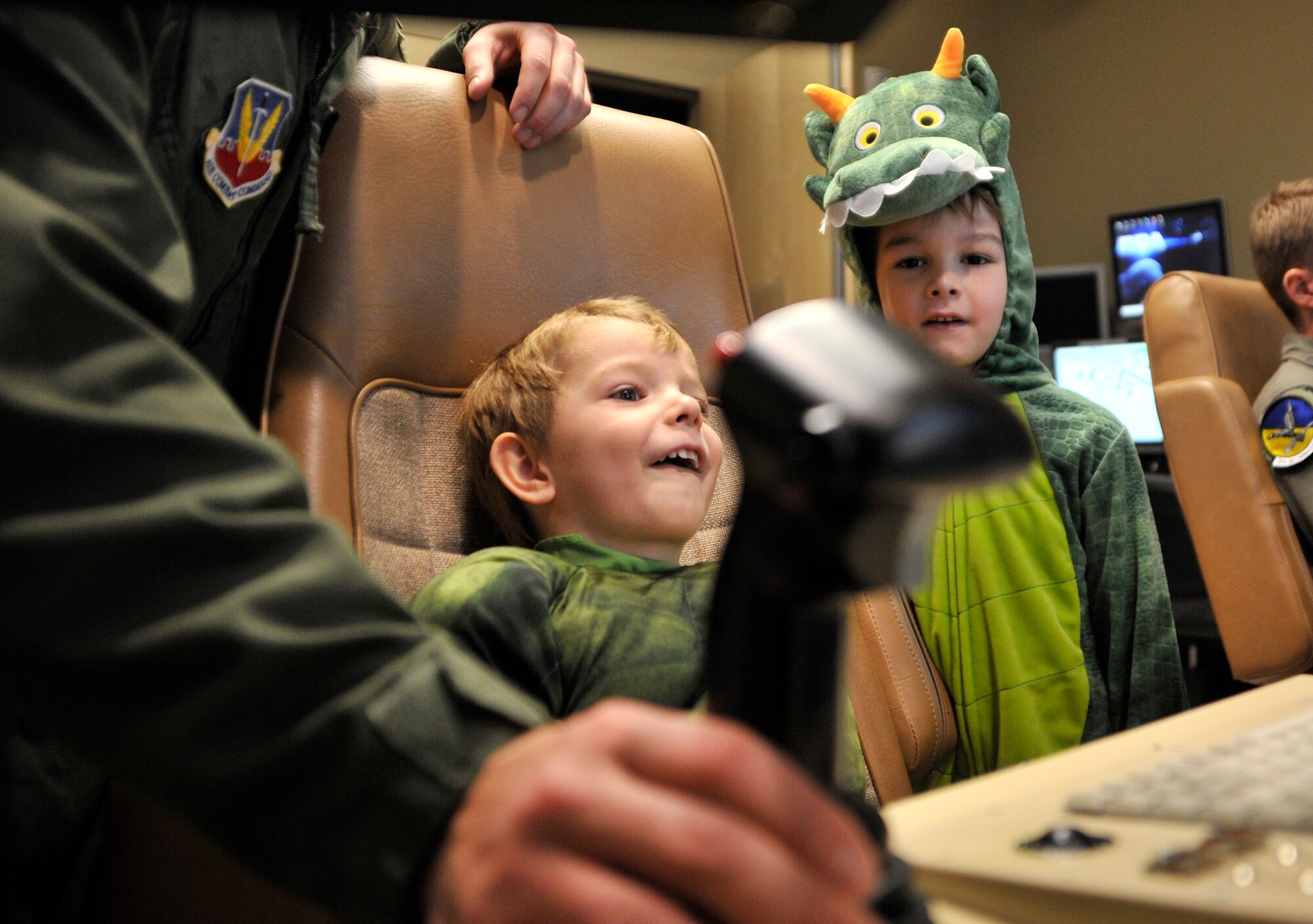 Holden, 3, left, and Carson, 5, sons of Staff Sgt. Zachary, 867th Reconnaissance Squadron, watch the screen of a simulated ground control station as a missile strikes a target during the first Team Creech Children’s Halloween Party Oct. 25, 2014, on Creech Air Force Base, Nevada. The flight simulator building was decorated with a Halloween theme and open to the families. Children were allowed, with supervision from authorized personnel, to sit in a ground control station and fly a simulated remotely piloted aircraft. This experience helped children gain a better understanding of their parents’ job and mission. (U.S. Air Force photo by Airman 1st Class Christian Clausen/Released)
