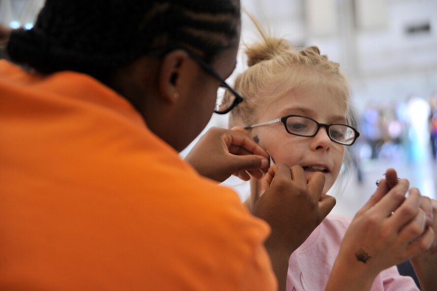 Alayna, 11, right, daughter of Staff Sgt. Ryan, 42nd Attack Squadron, gets her face painted during the first Team Creech Children’s Halloween Party Oct. 25, 2014, on Creech Air Force Base, Nevada. Activities included in the day’s events were face painting, family photos, ring toss, ping pong, treat walk, book reading, and many more. The Fire Department also provided a fire truck for the children to sit in and explore. (U.S. Air Force photo by Airman 1st Class Christian Clausen/Released)