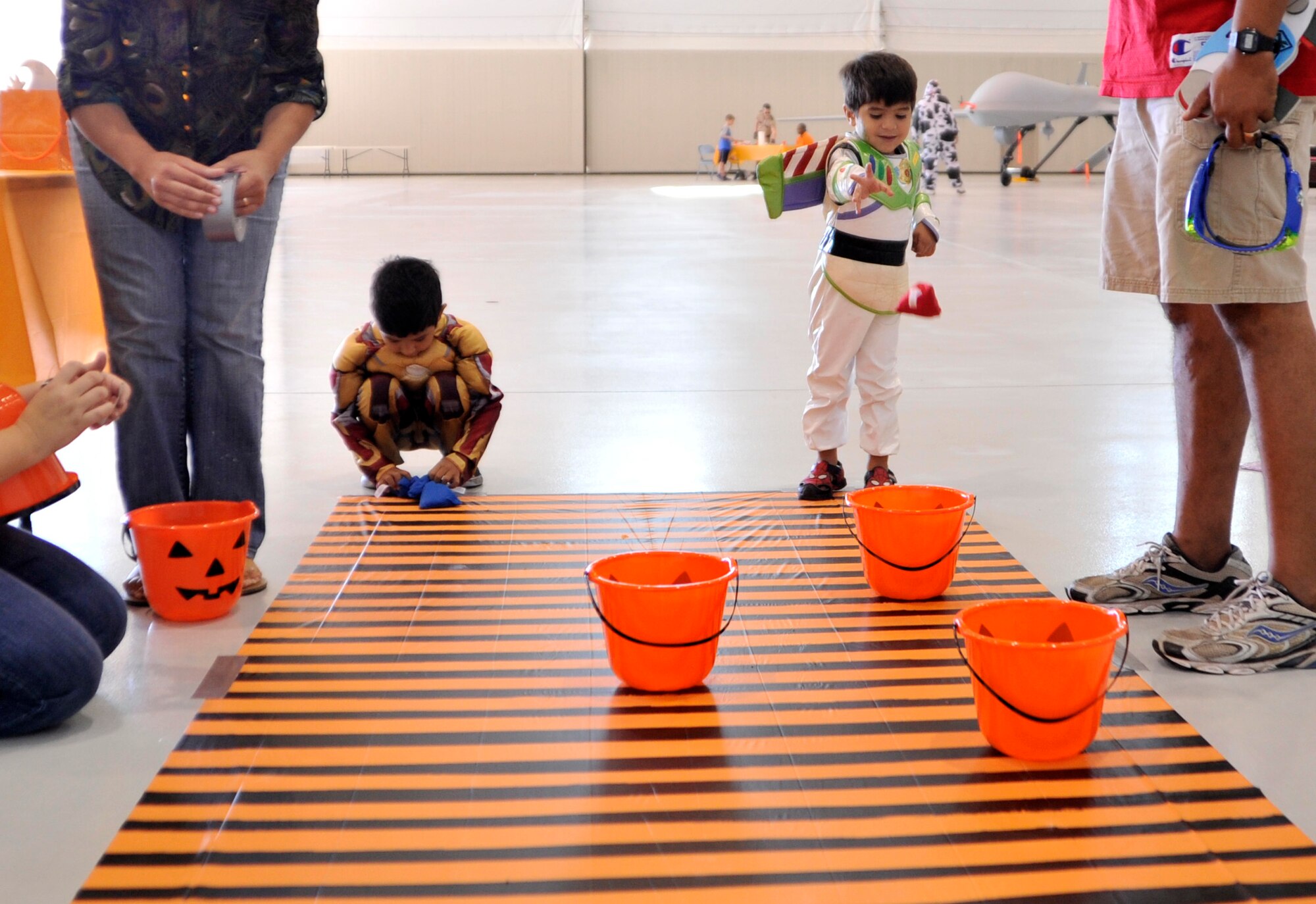 Victor, 5, left, and Teo, 3, sons of Tech. Sgt. Richard, 432nd Operations Support Squadron, play bean-bag toss at the first Team Creech Children’s Halloween Party Oct. 25, 2014, on Creech Air Force Base, Nevada. The event gave children the opportunity for a day of fun with other families and helped showcase what their parents do on a daily basis. (U.S. Air Force photo by Airman 1st Class Christian Clausen/Released)