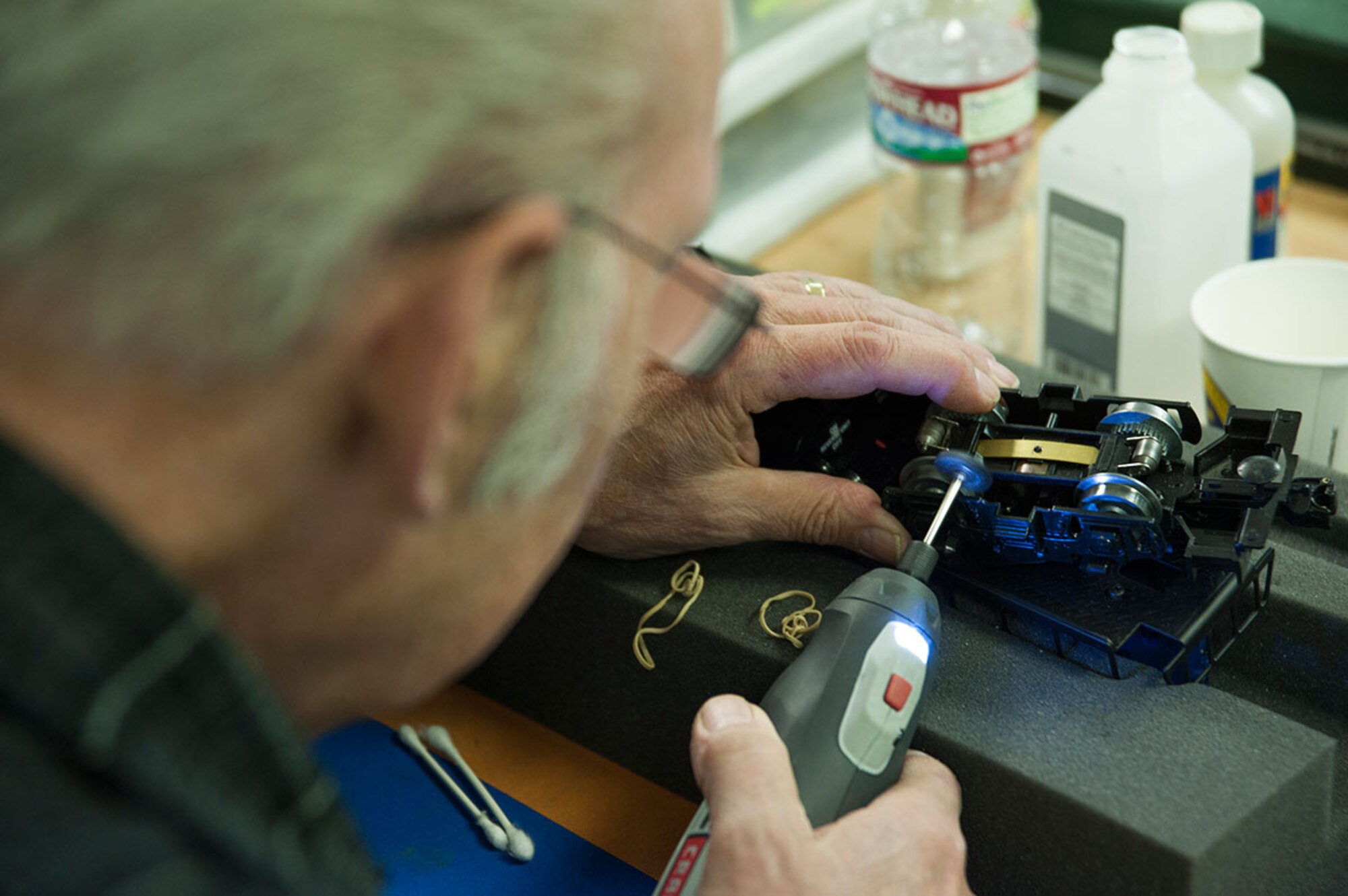 Steve St. Peter, a retired aerial photographer, cleans dust and dirt off the bottom of a model train on Joint Base Elmendorf-Richardson, Alaska, Oct. 21, 2014. Cleaning the model’s wheels ensures the train connects with the track, making it run smoothly and efficiently. St. Peter is a member of the Military Society of Model Railroad Engineers, located in the basement of Building 7153. (U.S. Air Force photo/Airman 1st Class Tammie Ramsouer)