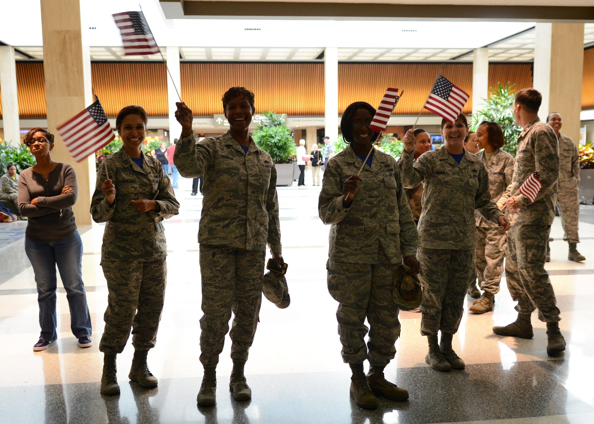 U.S. Air Force Airmen assigned to the 633rd Force Support Squadron wave American flags at Norfolk International Airport in Norfolk, Va., Oct. 24, 2014. The force support Airmen deployed to Southwest Asia to provide mission-sustaining combat support. (U.S. Air Force photo by Airman 1st Class Devin Scott Michaels/Released)
