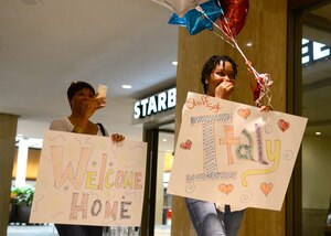 Kayla Milum and Keisha Mathew smile at the sight of Milum’s fiancé, U.S. Air Force Staff Sgt. Italy Williams, 633rd Force Support Squadron food services shift leader, at Norfolk International Airport in Norfolk, Va., Oct. 24, 2014. Several 633rd FSS Airmen returned from a three-month deployment to Southwest Asia. (U.S. Air Force photo by Airman 1st Class Devin Scott Michaels/Released)