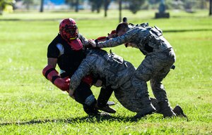U.S. Air Force Airmen assigned to the 633rd Security Forces Squadron perform foot pursuit training at Langley Air Force Base, Va., Oct. 28, 2014. SFS Airmen tested their abilities to tackle and restrain a threatening individual without the use of deadly force.  (U.S. Air Force photo by Senior Airman Kayla Newman/Released) 