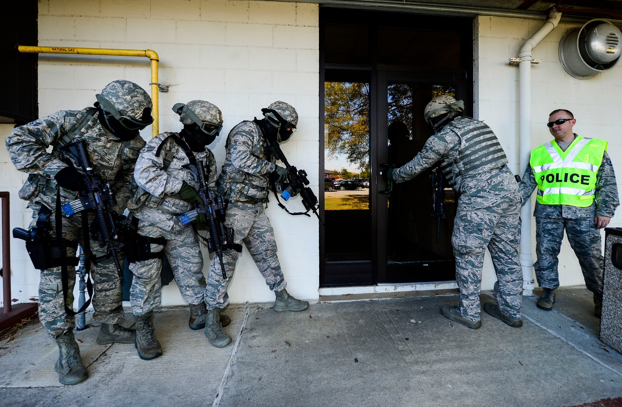 A U.S. Air Force fire team assigned to the 633rd Security Forces Squadron prepares to enter a building during training at Langley Air Force Base, Va., Oct. 28, 2014. The SFS Airmen perform training every six months on active shooter situations.  (U.S. Air Force photo by Senior Airman Kayla Newman/Released) 