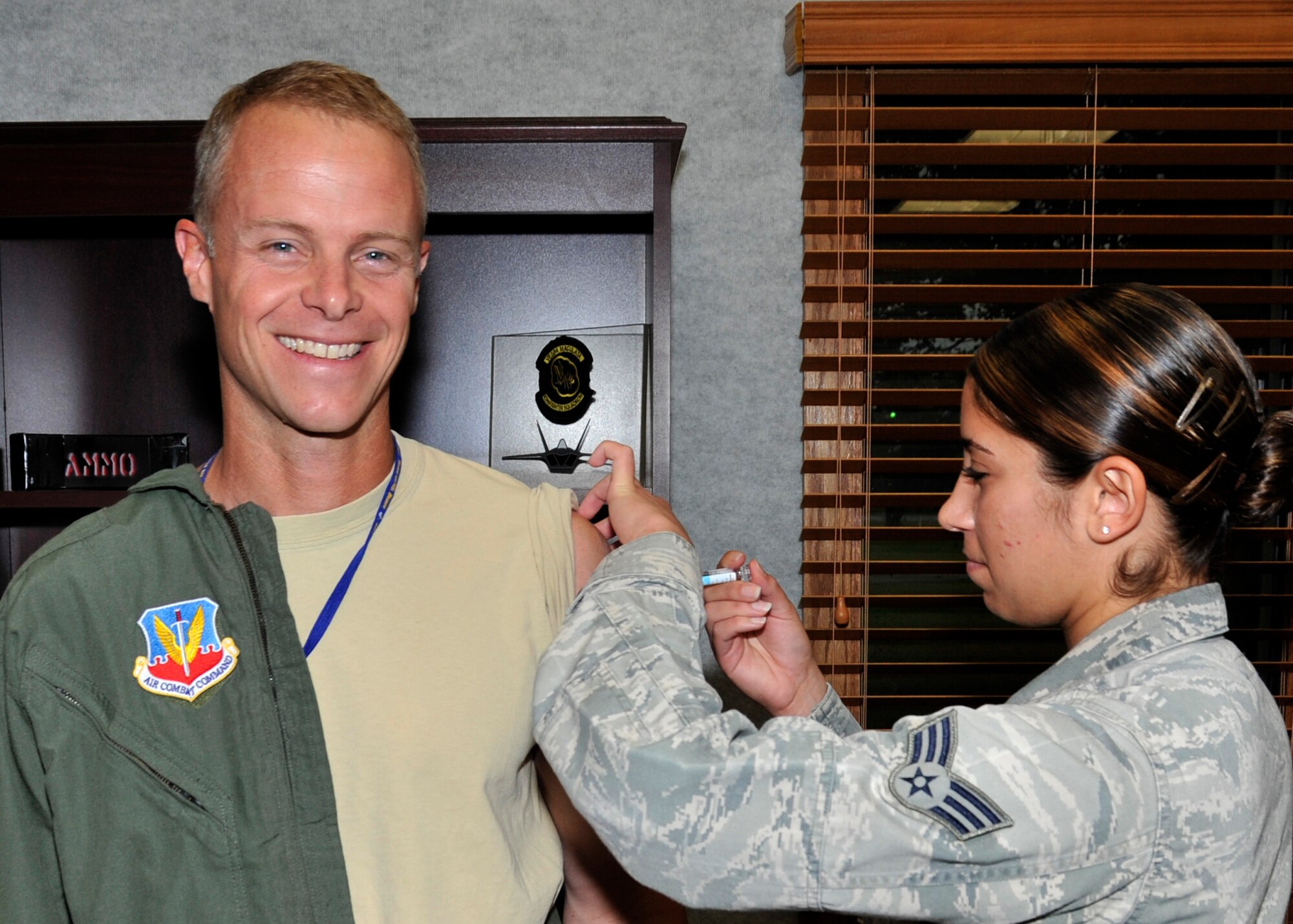 Colonel Derek C. France, 325th Fighter Wing commander, receives his yearly flu shot from Senior Airman Nadima Farrah-Castillo, 325th Medical Group flight medicine medical technician, Oct. 14 at the Wing building. Seasonal flu is a contagious respiratory illness caused by flu viruses that can spread between people and can cause mild to severe illness. (U.S. Air Force photo by Airman 1st Class Sergio A. Gamboa)