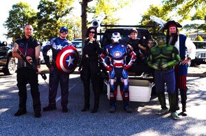 U.S. Air Force Lt. Col. Gregory Beaulieu, 633rd Force Support Squadron commander, far right, congratulates members of the Air Combat Command A4, Maintenance and Logistics Directorate, on winning third place in the Trunk-or-Treat costume contest at Langley Air Force Base, Va., Oct. 25, 2014. First, second and third place costume winners received medals. (Courtesy photo)
