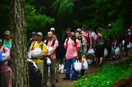 Members from Joint Task Force-Bravo, wait in line to give their bags of donated food and clothes to villagers in Potrerillos, Siguatepeque, Honduras, Oct. 25, 2014.  As part of the 57th Chapel Hike, more than 130 members assigned to Joint Task Force-Bravo laced up their hiking boots and trekked almost four miles up a mountain to help deliver over 3,500-pounds of donated dry goods to villagers in need. (U.S. Air Force photo/Tech. Sgt. Heather Redman)