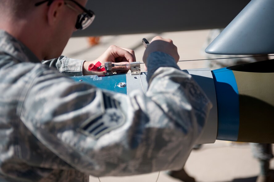 Senior Airman Sammy McCain, 49th Aircraft Maintenance Squadron MQ-9 Reaper weapons load crew member, prepares a GBU-12 Paveway bomb for an MQ-9 at Holloman Air Force Base, N.M., Oct. 24. Load crew competitions are held on a quarterly basis and are used to help build morale through friendly competition.  (U.S. Air Force photo by Senior Airman Daniel Liddicoet/Released)