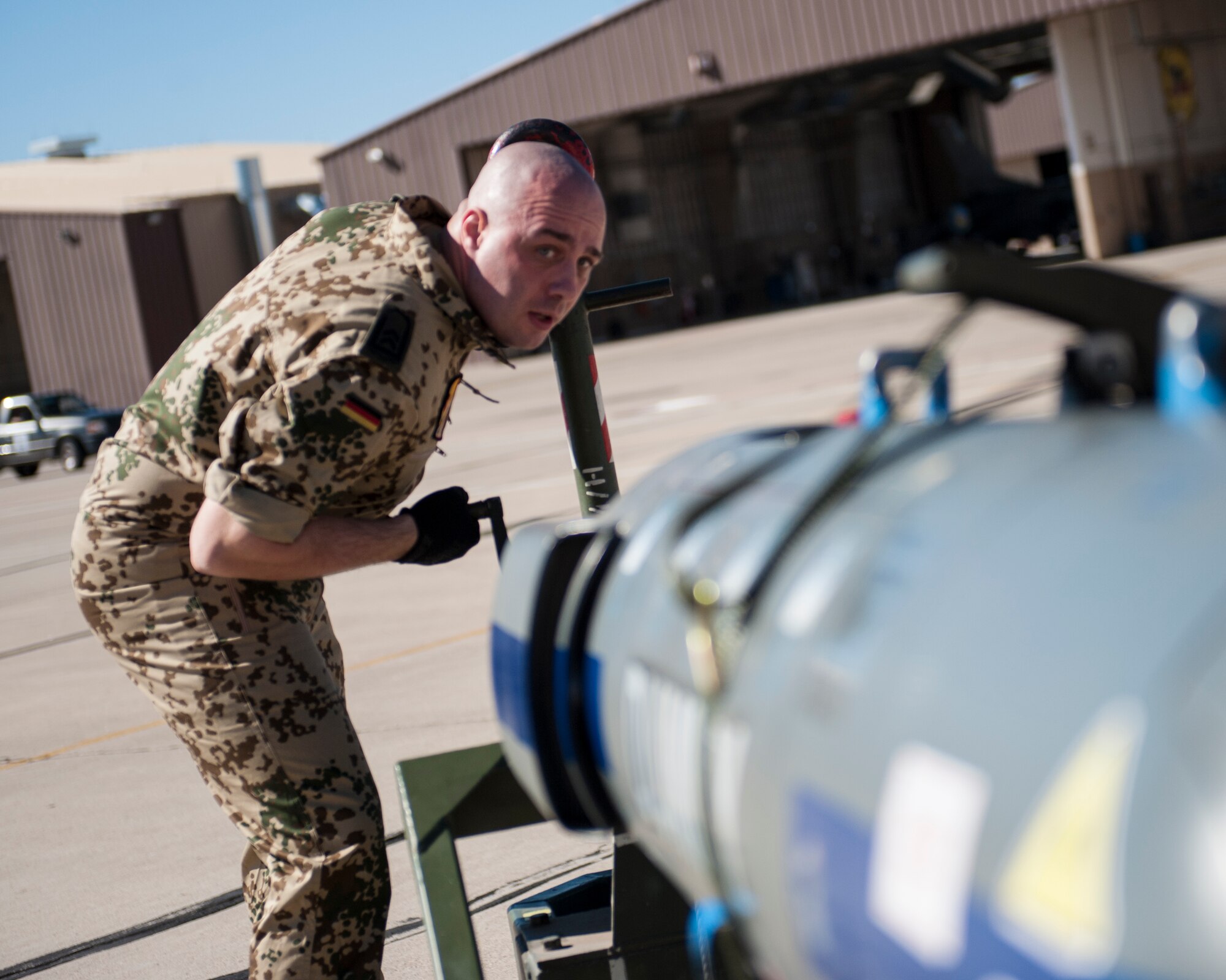 Tech. Sgt. Andre Wells, German Air Force Flying Training Center crew chief, prepares an inert missile for a Tornado jet during a quarterly load crew competition at Holloman Air Force Base, N.M., Oct. 24. The GAF, F-16 Fighting Falcon and MQ-9 Reaper were all pitted against each other to see who could load weapons the most efficiently and with the least amount of procedural errors. (U.S. Air Force photo by Senior Airman Daniel Liddicoet/Released)