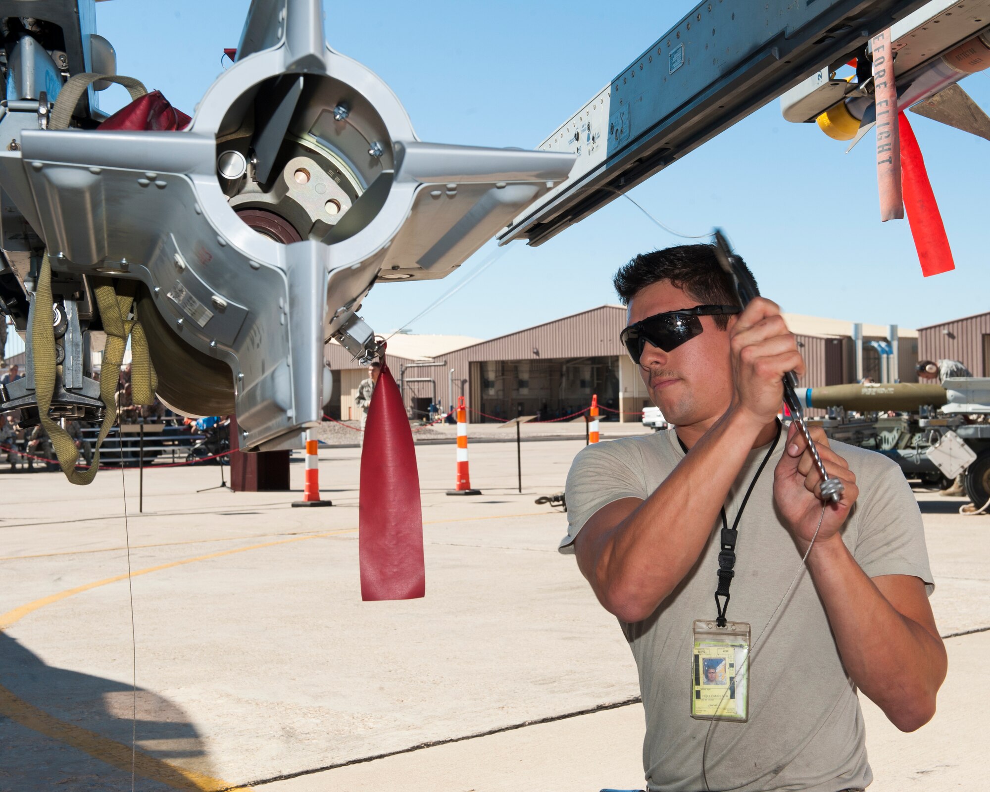 Senior Airman Angel Frimel, 54th Fighter Group F-16 Fighting Falcon weapons load crew member, secures an inert AIM-9 Sidewinder missile at Holloman Air Force Base, N.M., July 11. The F-16 load crew participated in the competition to have their skills evaluated alongside the MQ-9 Reaper and German Tornado load crews. For the competition, points are awarded for weapons-loading, toolkit inspection, and uniform inspection. (U.S. Air Force photo by Senior Airman Daniel Liddicoet/Released)