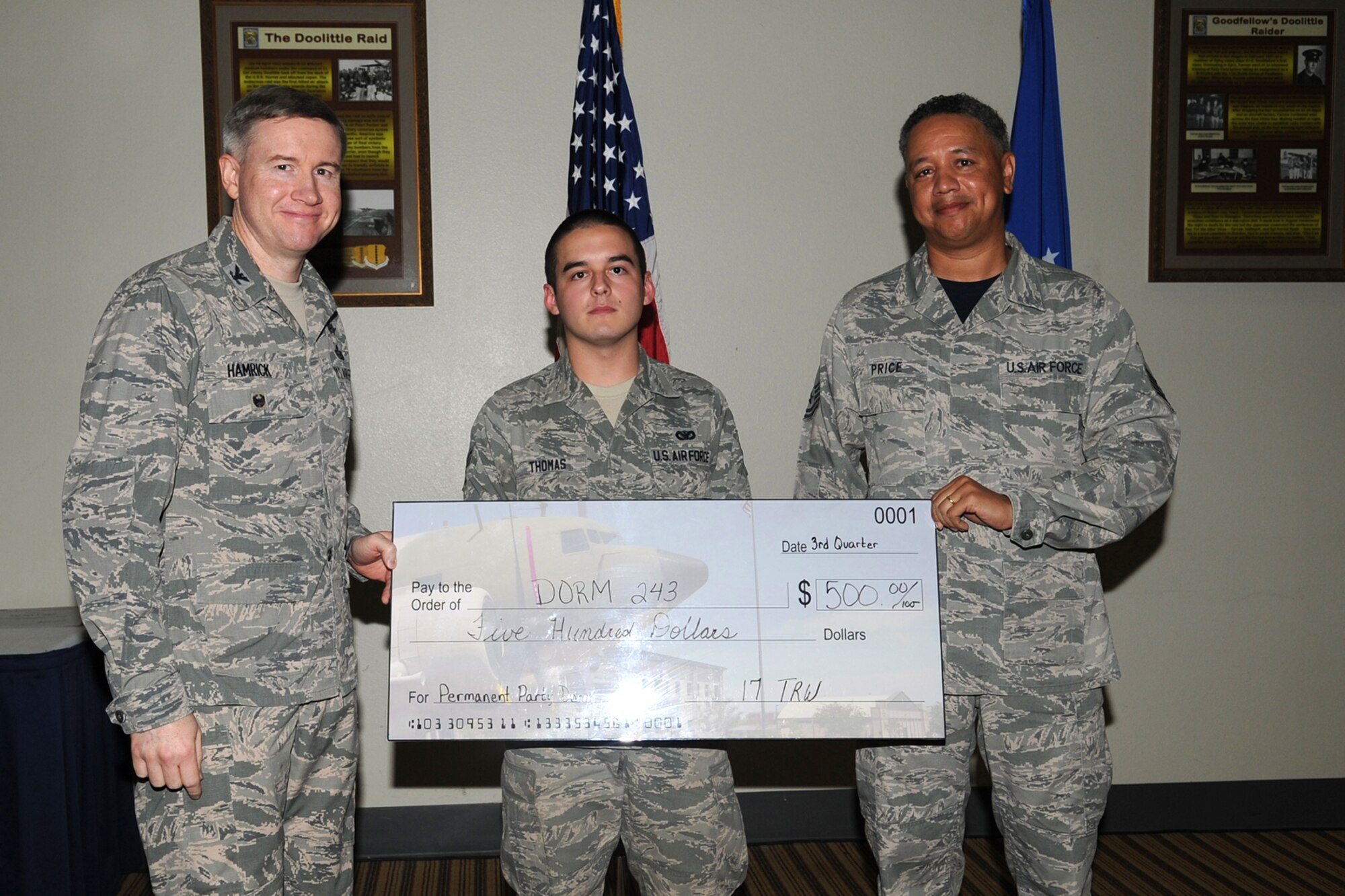 GOODFELLOW AIR FORCE BASE, Texas - Col. Terry J. Hamrick Jr., 17th Training Wing Vice Commander, and Chief Master Sgt. William E. Price, 17th Communications Squadron superintendent, present Senior Airman Justin M. Thomas, 17th Security Forces Squadron, with the Team Goodfellow Permanent Party Dormitory of the Quarter award during the wing quarterly awards ceremony at the Event Center Oct. 24. (U.S. Air Force photo/ Staff Sgt. Laura R. McFarlane)