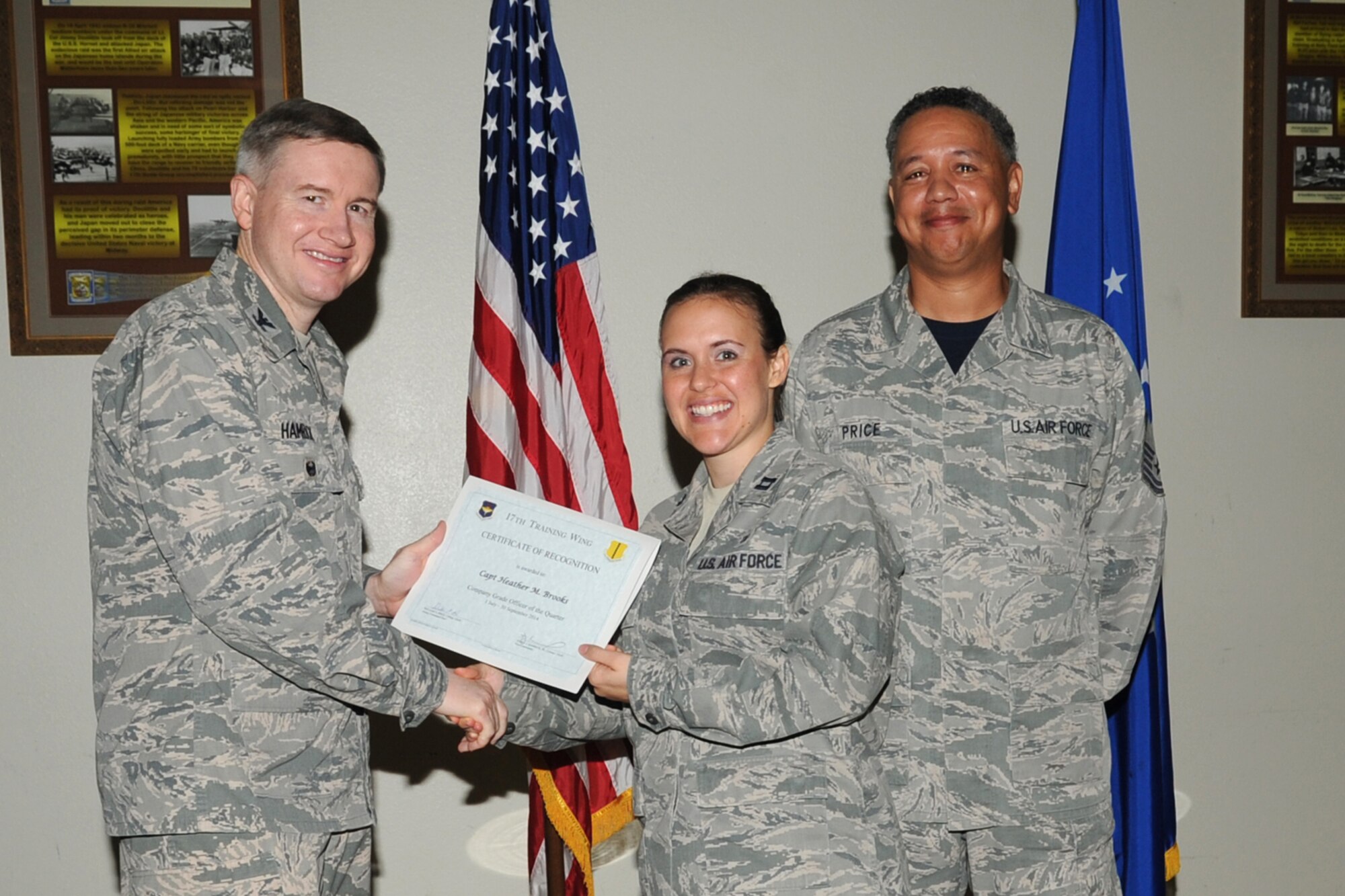 GOODFELLOW AIR FORCE BASE, Texas - Col. Terry J. Hamrick Jr., 17th Training Wing Vice Commander, and Chief Master Sgt. William E. Price, 17th Communications Squadron superintendent, present the 17th Training Wing Company Grade Officer of the Quarter Category award to Capt. Heather M. Brooks, 17th Medical Operations Squadron, during the wing quarterly awards ceremony at the Event Center Oct. 24. (U.S. Air Force photo/Staff Sgt. Laura R. McFarlane)