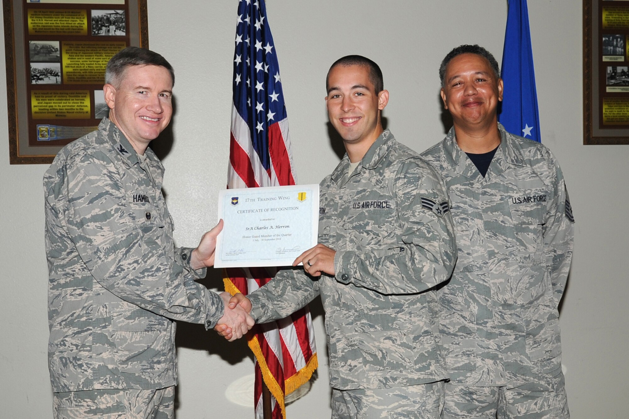 GOODFELLOW AIR FORCE BASE, Texas - Col. Terry J. Hamrick Jr., 17th Training Wing Vice Commander, and Chief Master Sgt. William E. Price, 17th Communications Squadron superintendent, present the 17th Training Wing Honor Guard of the Quarter award to Senior Airman Charles A. Herron, 17th Medical Support Squadron, during the wing quarterly awards ceremony at the Event Center Oct. 24. (U.S. Air Force photo/Staff Sgt. Laura R. McFarlane)