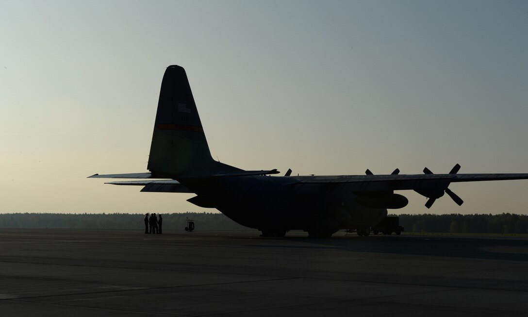 U.S. Air Force Airmen assigned to the 182nd Airlift Wing, Illinois Air National Guard, Peoria, Ill., stand under the wing of a C-130 Hercules cargo aircraft assigned to the 182nd AW before a “turkey shoot” training mission Oct. 24, 2014, at Powidz Air Base, Poland. The “turkey shoot” is comprised of an air drop and tactical landing competition. The 182nd AW supported rotation 15-1 hosted by the U.S. Air Force Aviation Detachment 1, 52nd Operations Group, from Lask Air Base, Poland. The rotation serves as part of bilateral training with Poland to maintain joint readiness, build interoperability and reassure regional allies and partners.(U.S. Air Force photo by Airman 1st Class Dylan Nuckolls/Released)