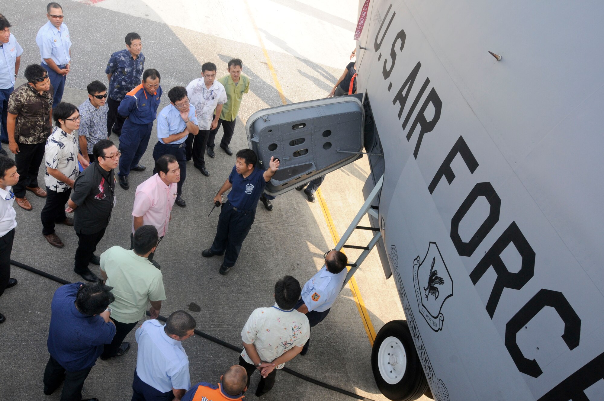 Masao Itokazu, 18th Civil Engineering Squadron crew chief, explains the different parts of a KC-135 Stratotanker to a group of local national first responders during an annual bilateral aircraft mishap hands-on training on Kadena Air Base, Japan, Oct. 28, 2014. The purpose of this training is to enhance Japanese firefighters' skills in responding to an aircraft fire as well as to enhance bilateral first responder cooperation. Approximately 50 local national representatives from local police, fire departments and other Japanese participants attended the training conducted by Kadena's fire department. (U.S. Air Force photo by Tech. Sgt. Darnell T. Cannady/Released)