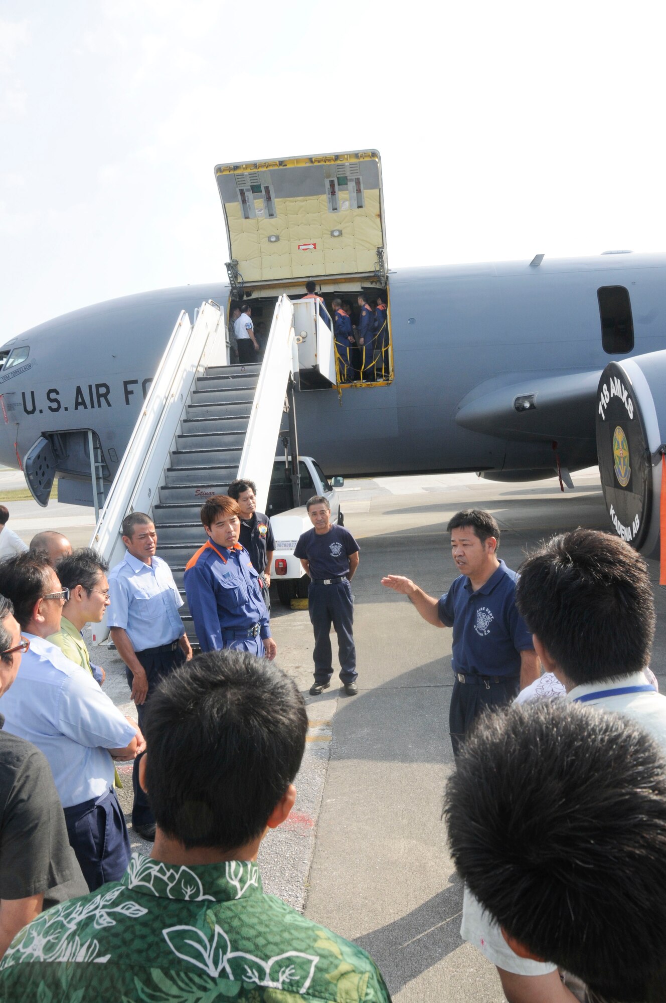 Masao Itokazu, 18th Civil Engineering Squadron crew chief, briefs the functionality of the KC-135 Stratotanker during an annual bilateral aircraft mishap hands-on training on Kadena Air Base, Japan, Oct. 28, 2014. Approximately 50 local national representatives from local police, fire departments and other Japanese participants attended the training conducted by Kadena's fire department. The hands-on training provided the first responders a great opportunity to understand characteristics of different aircraft and strengthen initial response capabilities. (U.S. Air Force photo by Tech. Sgt. Darnell T. Cannady/Released)