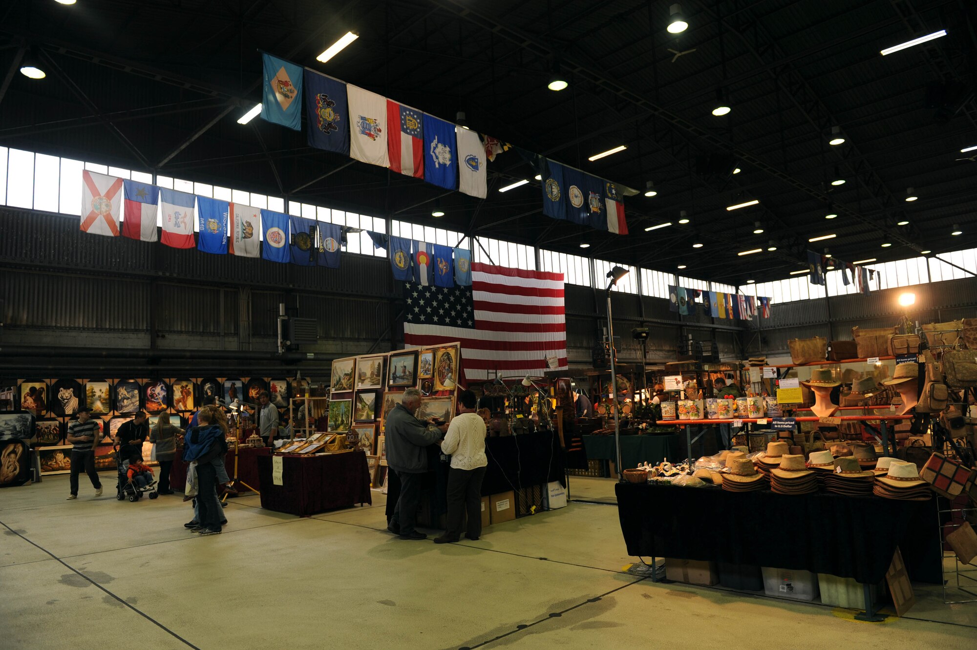 Spangdahlem community members browse through various merchandise during the 2014 Holiday Bazaar in Hangar 1 at Spangdahlem Air Base, Germany, Oct. 25, 2014. Spangdahlem Airmen and their families had the opportunity to enjoy food, live entertainment and assorted goods from European vendors. (U.S. Air Force photo by Airman 1st Class Timothy Kim/Released)