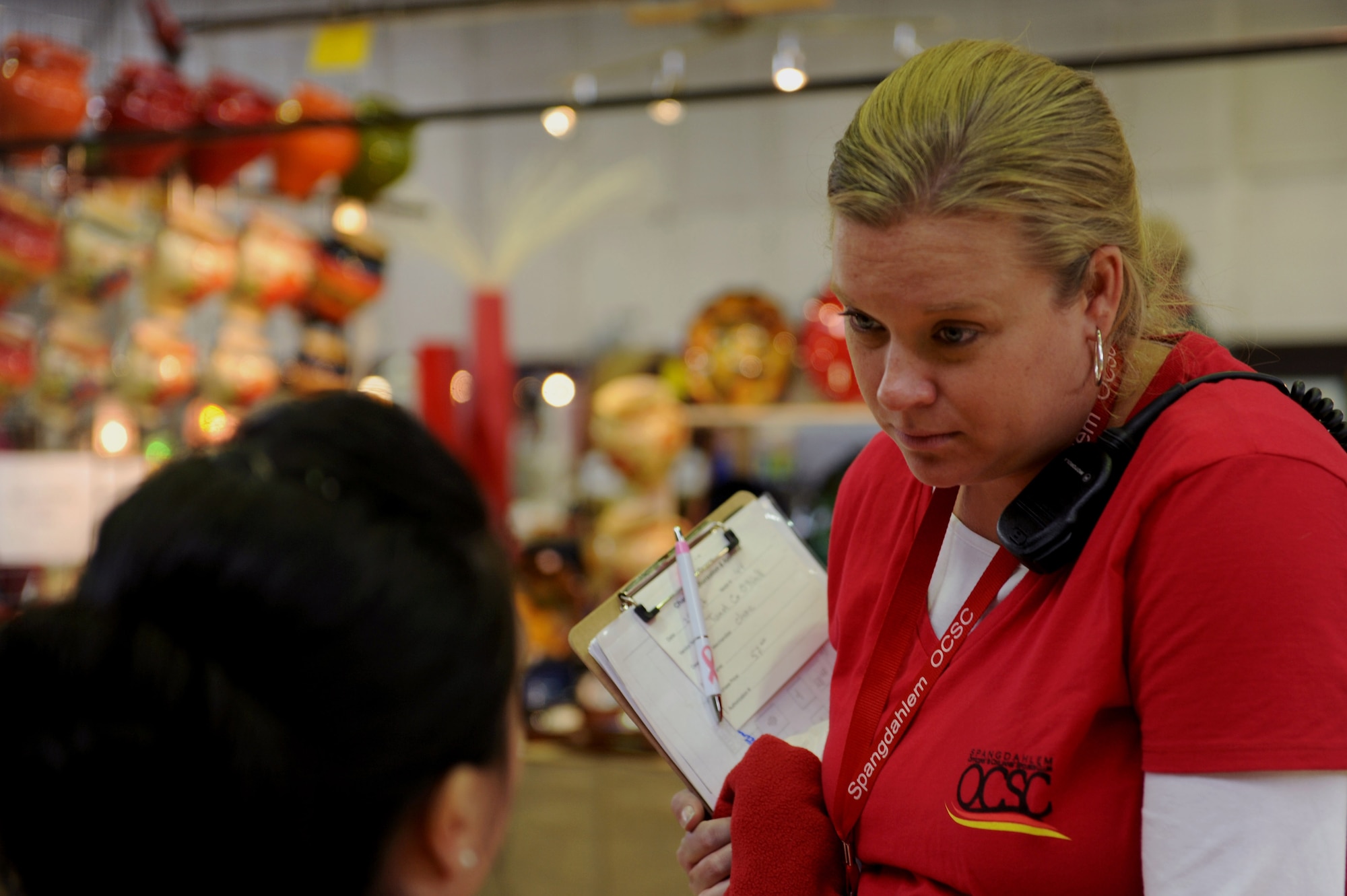 Erica Smith, a Sexual Assault Prevention and Response victim advocate from Lexington, S.C., and wife of U.S. Air Force Capt. Warren Smith, a 52nd Equipment Maintenance Squadron operations officer, talks with a fellow bazaar board member during the 2014 Holiday Bazaar in Hangar 1 at Spangdahlem Air Base, Germany, Oct. 25, 2014. Smith organized the event as the Bazaar Chair of the Officers’ and Civilians’ Spouses Club. (U.S. Air Force photo by Airman 1st Class Timothy Kim/Released)