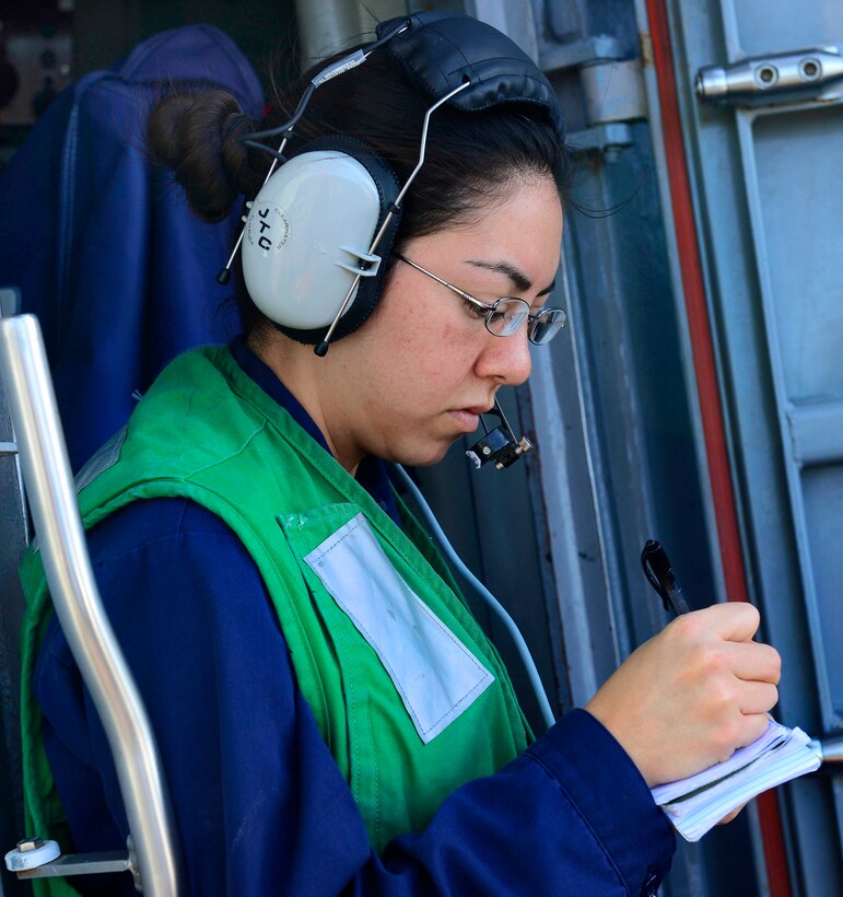 U.S. Navy Petty Officer 2nd Class Stephanie Nunez takes note of how many pallets of goods have been delivered to the Arleigh Burke-class guided-missile destroyer USS Sterett during a replenishment-at-sea in the Pacific Ocean, Oct. 19, 2014. Nunez is an interior communications electrician.