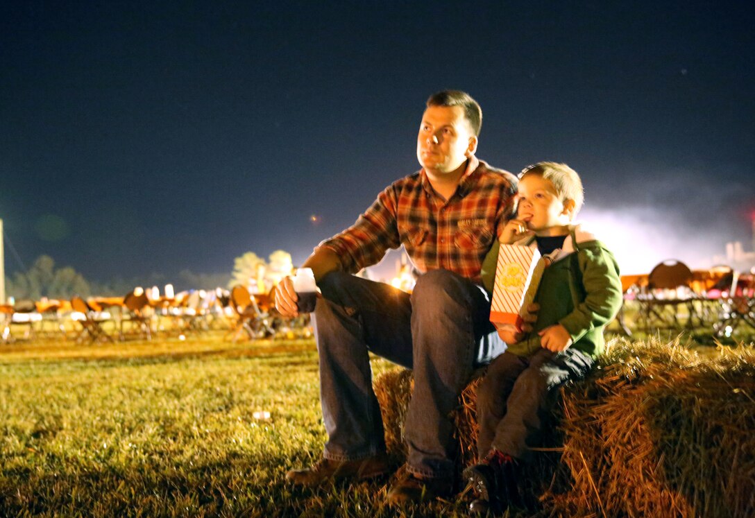 Sgt. Johnathan Barker, left, shares popcorn with his 2-year-old son as they watch the movie “Hocus Pocus” during the Marine Aircraft Group 28 Fall Festival at Marine Corps Air Station Cherry Point, N.C., Oct, 23, 2014. The annual festival featured free food, games and entertainment for Marines and their families. Barker is the motor transport chief with Marine Air Control Squadron 2.